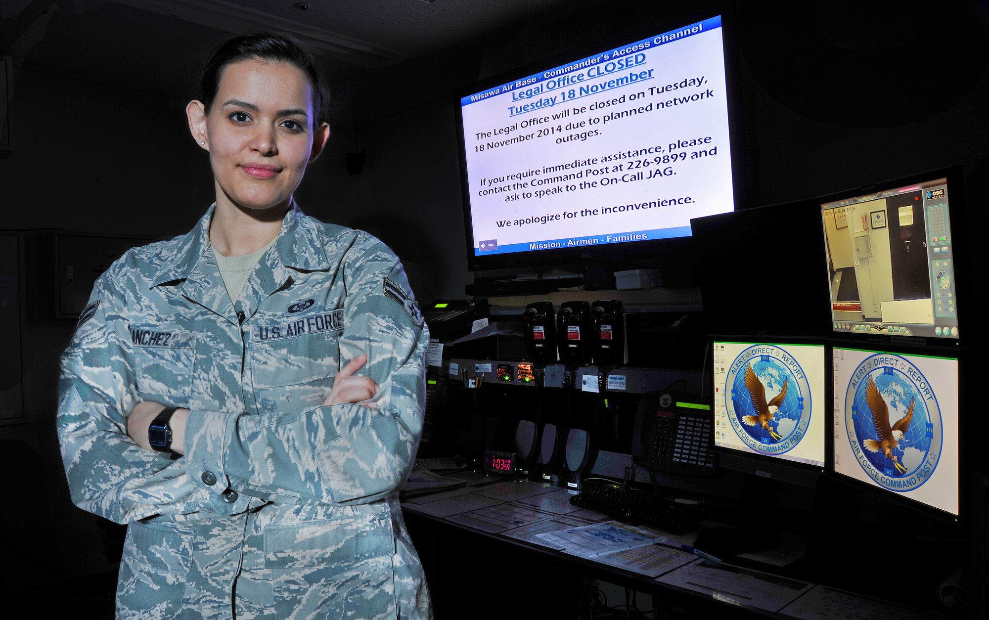 U.S. Air Force Airman 1st Class Luz Sanchez, emergency actions controller assigned to the 35th Fighter Wing's Command Post, poses for a picture at her work station at Misawa Air Base, Japan, Nov. 19, 2014. As an emergency action controller she ensures proper flow of information between the installation and higher headquarters during emergencies including day-to-day mission activities and operations. By maintaining in constant contact with all essential personnel during crisis situations she is able to relay information to the appropriate agencies. (U.S. Air Force photo/Senior Airman Jose L. Hernandez-Domitilo/Released)