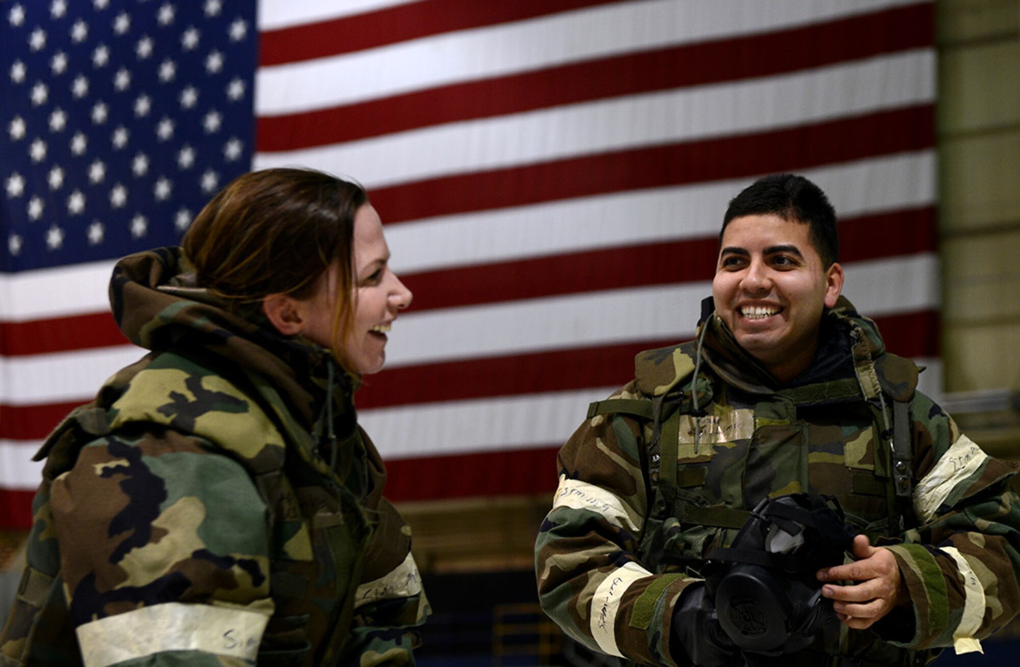 Staff Sgt. Louis Limon, an electrician with the 773d Civil Engineer Squadron and Captain Jennifer Franks, an operating room nurse with the 673d Surgical Operations Squadron shed their MOPP gear in Hangar 1 as part of the Polar Force 14-8 exercise October 30, 2014. Polar Force 14-8 is designed to assess Airman readiness and provide direction for any further training that may be needed. (U.S. Air Force Photo/Airman 1st Class Kyle Johnson)