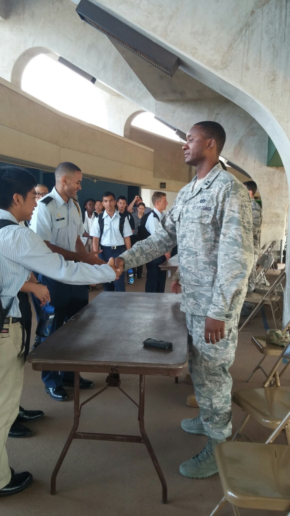 Air Force Capt. Marcus Hunt, Hickam Company Grade Officer Council vice president, shakes hands with an Air Force Reserve Officer Training Corps Detachment 175 cadet during a career day at the University of Hawaii Nov. 13, 2014. About 80 UH students attended the Leadership Laboratory, which provided the prospective new officers insight into the various Air Force Specialty Codes available. (U.S. Air Force photo by 1st Lt. Andrea Dykes/RELEASED)