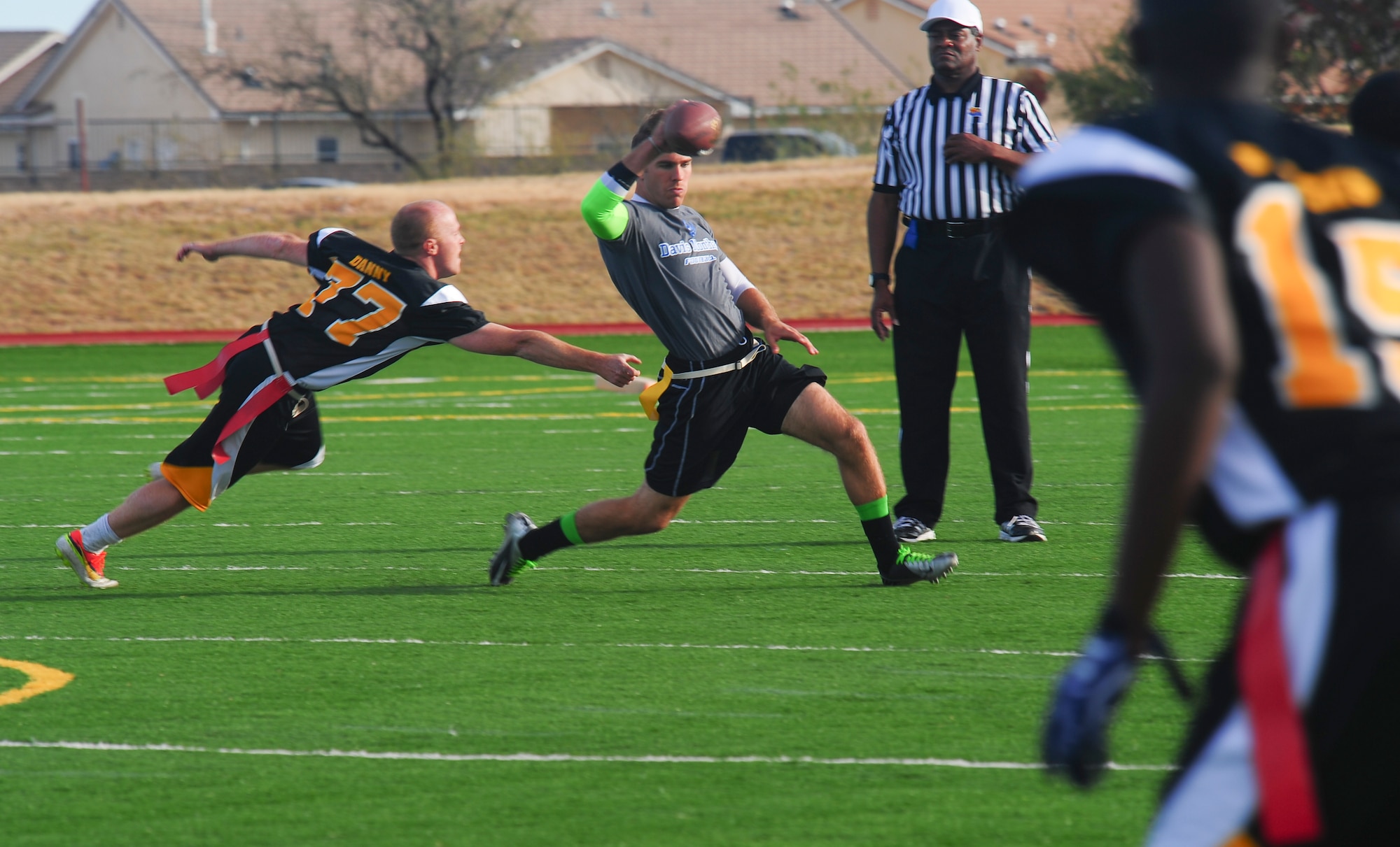 U.S. Air Force Senior Airman Philip Taylor, Davis-Monthan Air Force Base Desert Lightning Team quarterback, dodges a Black Knights defensive player during the annual Turkey Bowl at Fort Huachuca, Ariz., Nov. 14, 2014.  D-M’s Desert Lightning Team scored two touchdowns in the final 45 seconds leading them to win 18-7. (U.S. Air Force Photo by Staff Sgt. Angela Ruiz/Released)