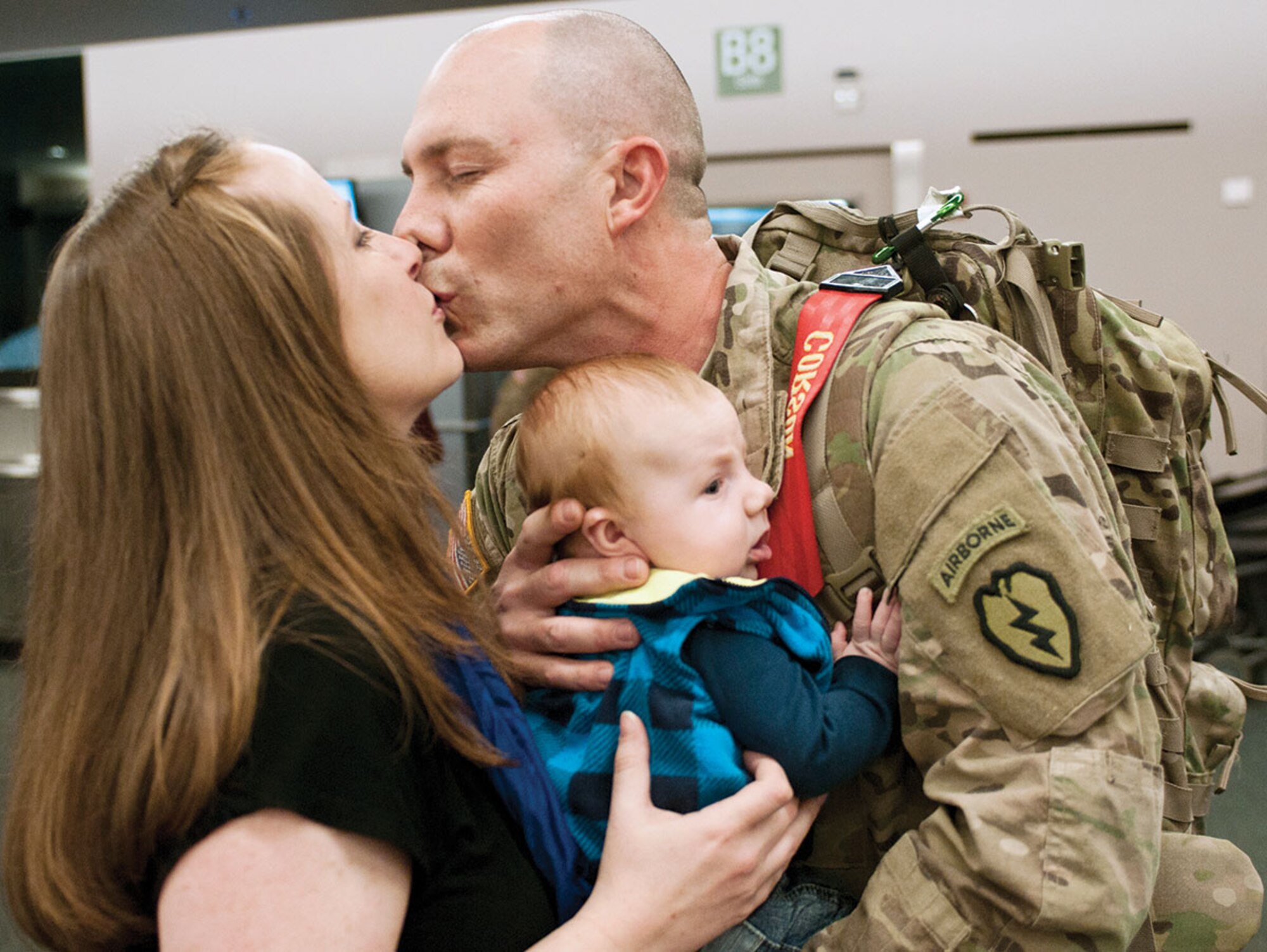 Army Maj. Robert Corson, an intensive care unit registered nurse with the 8th Forward Surgical Team, greets his wife, Shelley, after meeting his son Benjamin for the first time at Ted Stevens International Airport Nov. 4. Stevens and seven other 8th FST team members returned to a large group of family, friends and fellow Soldiers. (U.S. Army Photo/Staff Sgt. Daniel Love)