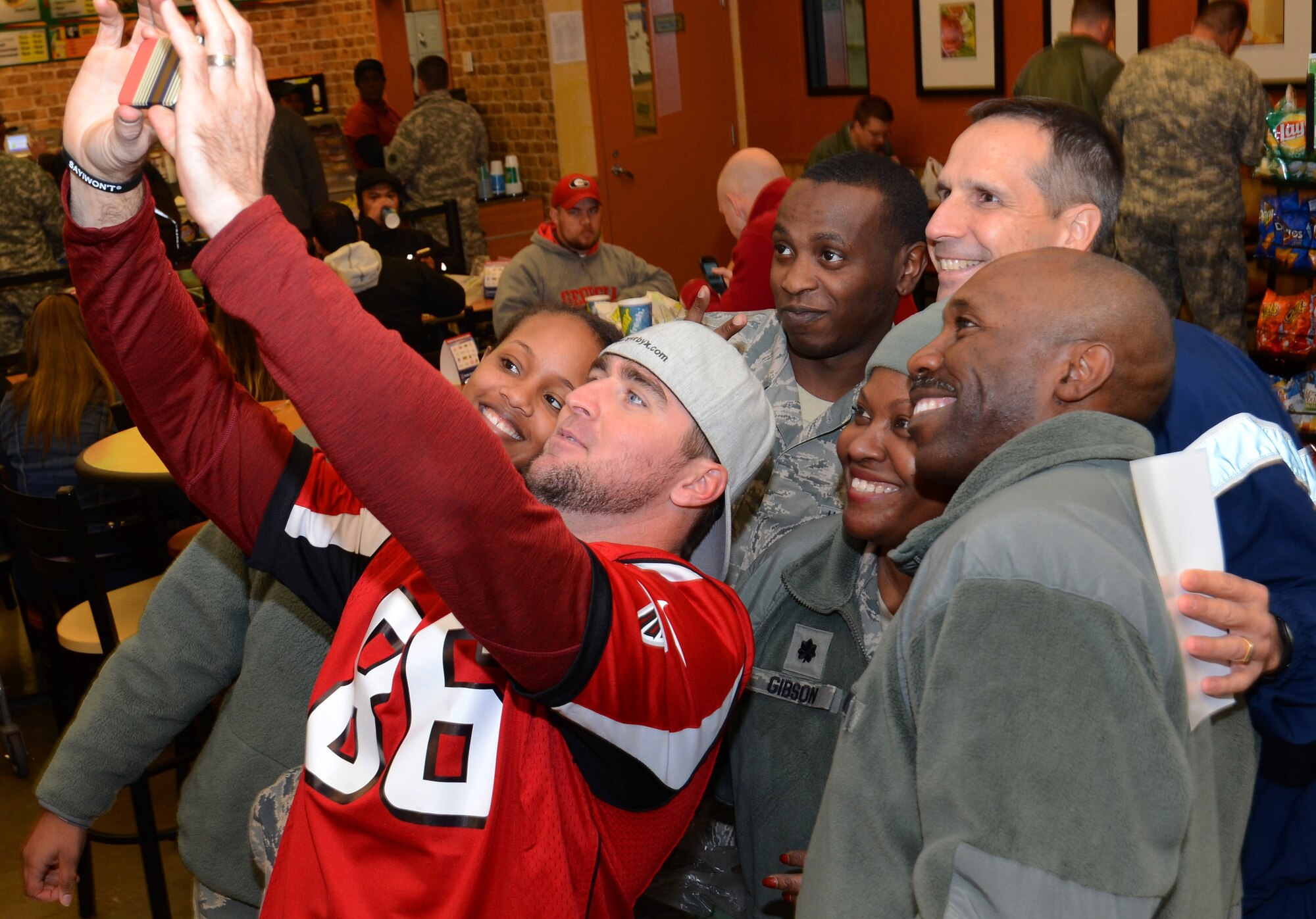 Atlanta Falcons player Bear Pascoe, shoots a selfie with Air Force service members at the Dobbins ARB base exchange in Marietta, Georgia, Nov. 18, 2014. Falcons players spent a couple of hours on the base to thank the various military service members assigned for what they do every day for our country.  (U.S. Air Force photo/ Brad Fallin /Released)