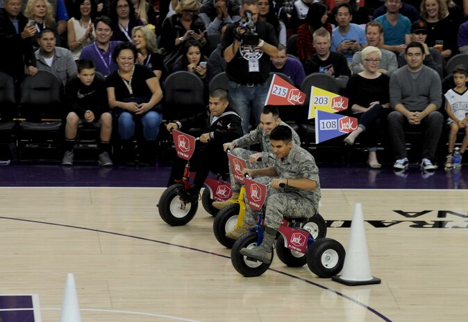 U.S. service members compete in a tricycle challenge during the Sacramento Kings Military Appreciation Night at the Sleep Train Arena in Sacramento, Calif., Nov. 15, 2014. The Kings held the military-themed game in honor of Veterans Day. (U.S. Air Force photo by Staff Sgt. Robert M. Trujillo/Released)
