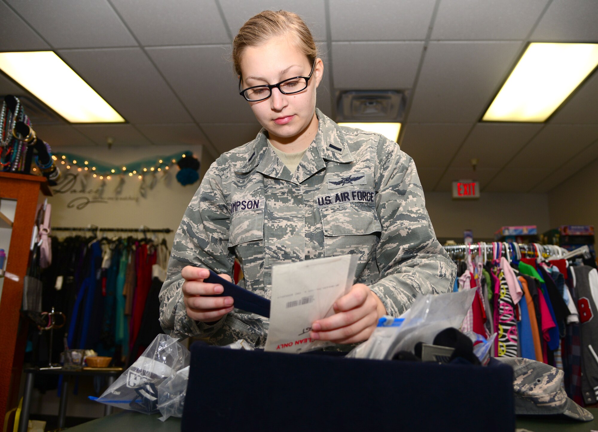 VANCE AIR FORCE BASE, Okla. -- 1st Lt. Kathrine Thompson, a 71st Mission Support Group executive officer, digs through a box of uniform ranks in the Airman’s Attic Nov. 12. The Airman’s Attic provides free clothes, kitchenware, childcare items and electronics for Airmen ranks E-1 through E-5. Officers are welcome to the Airman’s Attic as well, but they are limited to the uniform section. (U.S. Air Force photo/Senior Airman Frank Casciotta) 