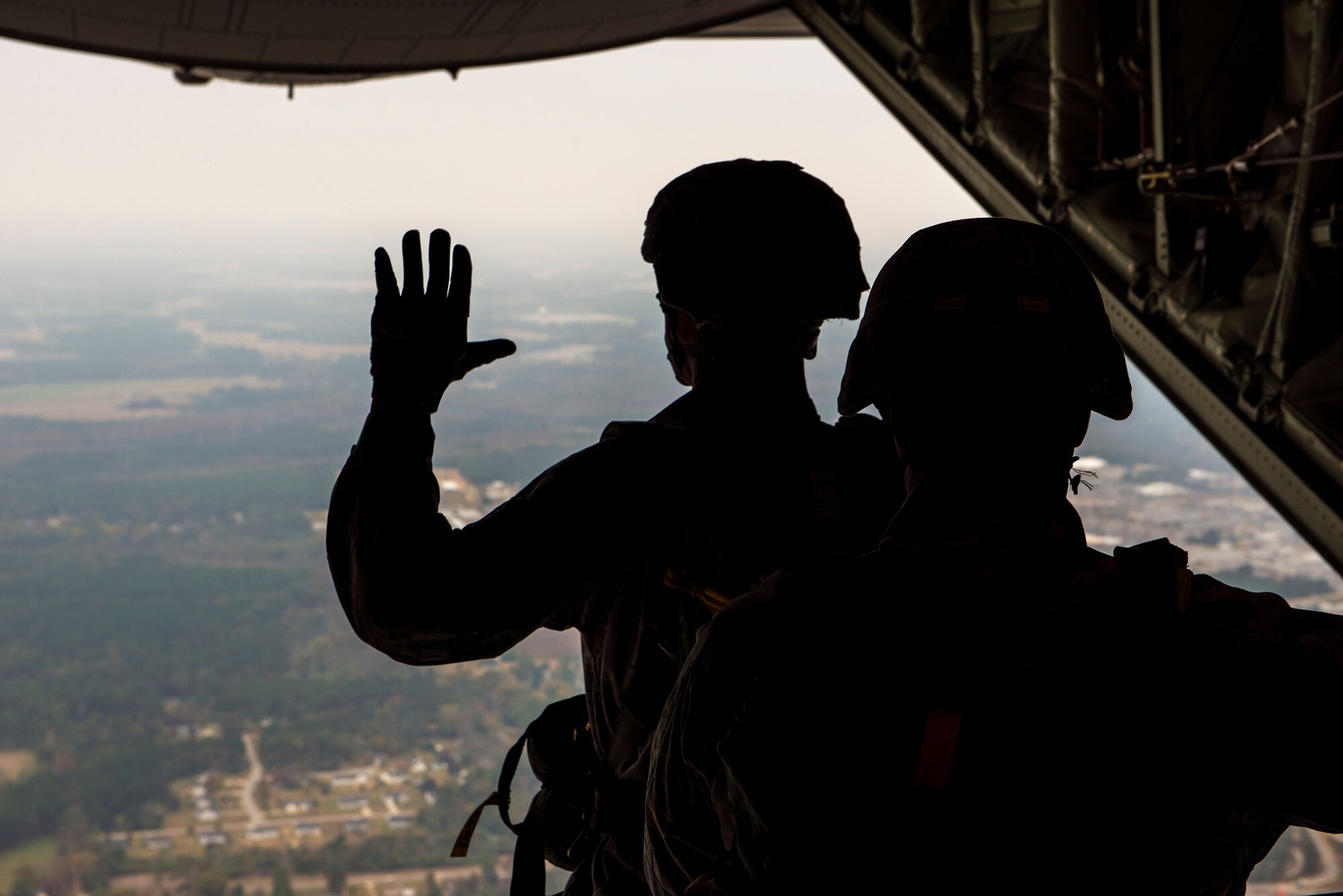 Airmen from the 820th Base Defense Group wait to time their static-line jump so they will be directly above their landing zone Nov. 13, 2014, over Moody Air Force Base, Ga. Nine defenders and the 93d Air Ground Operations Wing vice commander, Col. Eric Trychon jumped from an HC-130J Combat King II. (U.S. Air Force photo by Airman 1st Class Ryan Callaghan/Released)