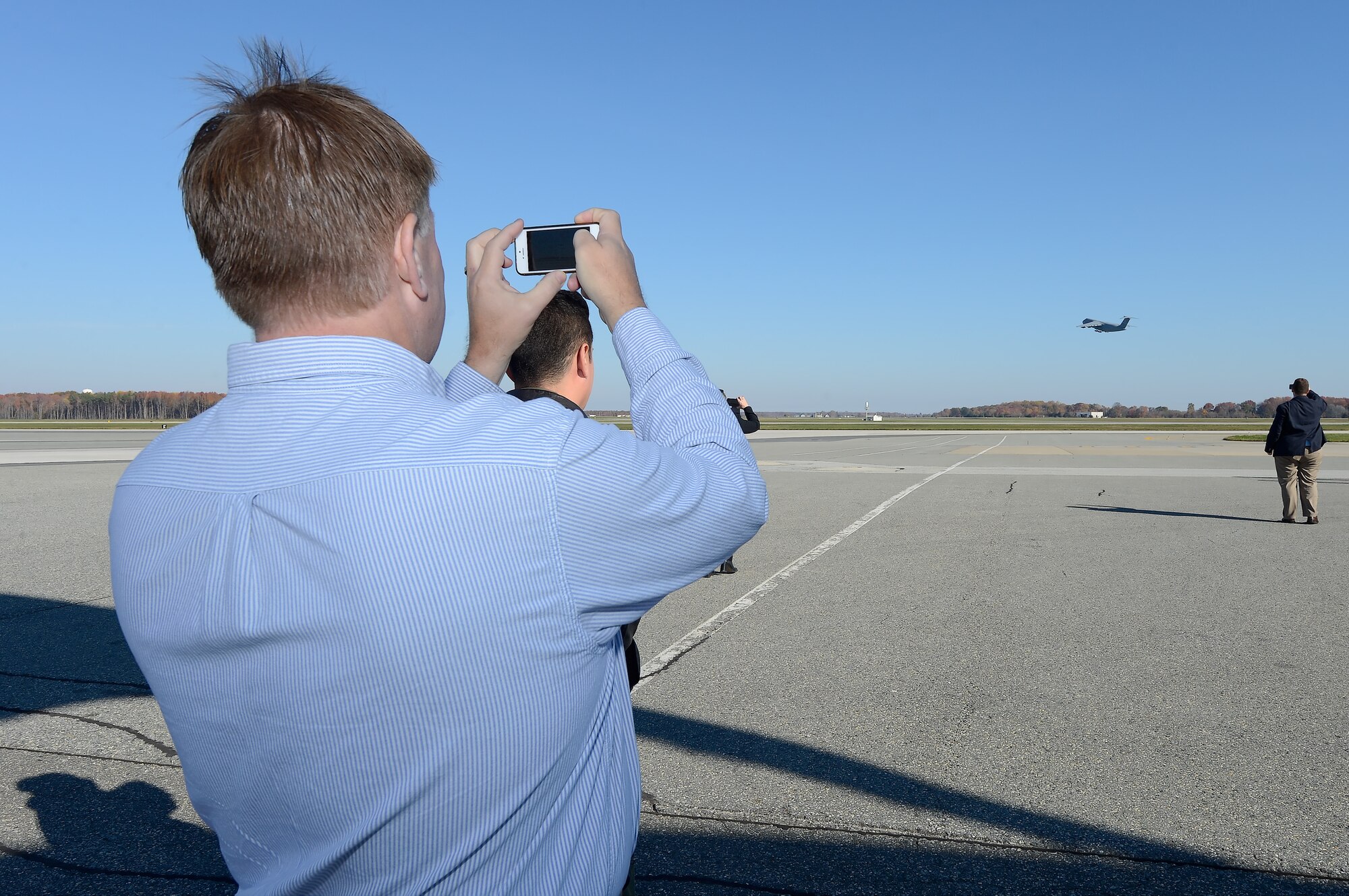 Kevin Phillipson, Kent County Women???s Journal publisher, takes a picture with his cell phone of a C-5M Super Galaxy taking off during a tour of Dover Air Force Base, Del., on Nov. 10, 2014. Phillipson attended the 2014 Military Construction (MILCON) Breakfast and tour that followed. (U.S. Air Force photo/Greg L. Davis)   