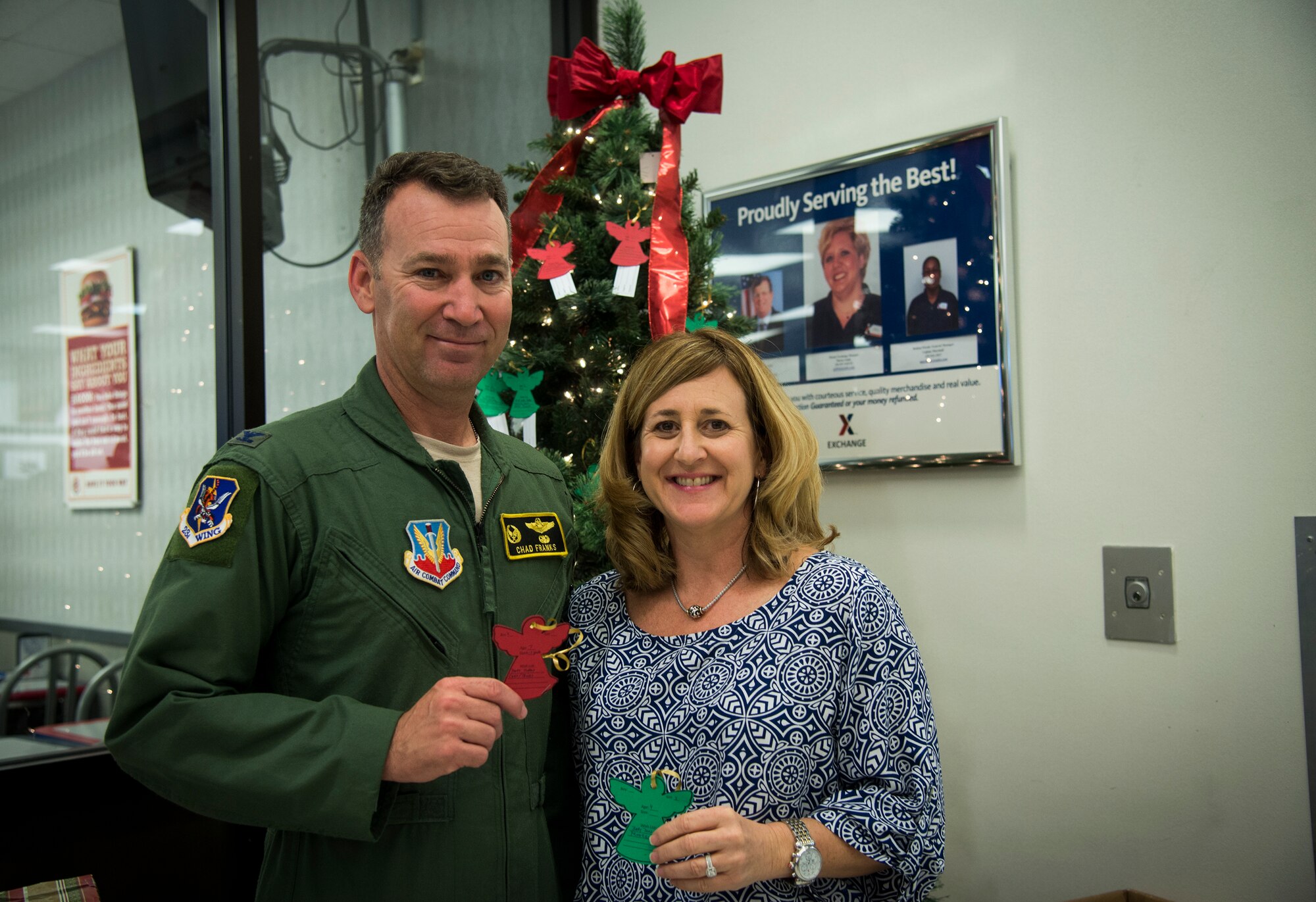 U.S. Air Force Col. Chad Franks, 23d Wing commander and wife Kim Franks pose for a photo during the Angel Tree Project unveiling Nov. 17, 2014. Franks and his wife picked the first ornaments to donate gifts to the children of Moody Airmen. (U.S. Air Force photo by Senior Airman Sandra Marrero/Released)
