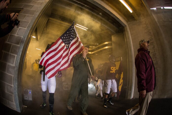 Technical Sergeant Ryan Radunzel, 16th Airlift Squadron loadmaster, prepares to run onto the field with the University of Minnesota football team Nov. 8, 2014, at TCF Bank Stadium, Minneapolis, Mn. Radunzel was selected by the university to carry the United States flag in honor of Veterans Day. The Gophers took on the University of Iowa Hawkeyes and defeated them 51-14. (University of Minnesota photo / Brace Hemmelgarn)