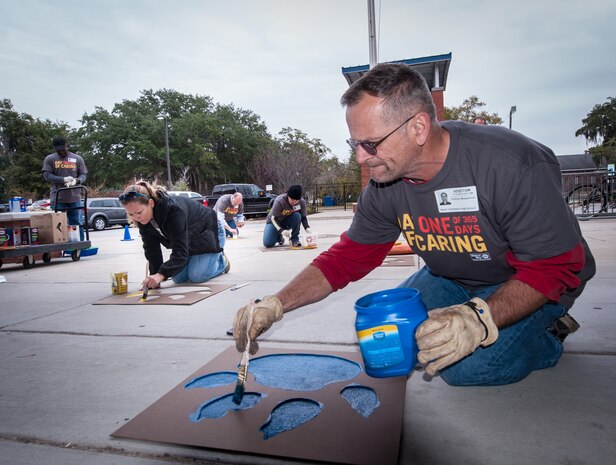 Employees from Space and Naval Warfare Systems Center Atlantic take part in the United Way Day of Caring, Nov. 14, 2014, by donating their time to paint tiger paws all over the North Charleston High School Campus to raise the schools esprit de corps in North Charleston, S.C. Hundreds of Joint Base Charleston Sailors, Airmen and civilians participated in the United Way Day of Caring, which provides an opportunity for volunteer teams to partner with local agencies and schools to increase community engagement.  (U.S. Navy photo/Joe Bullinger)
