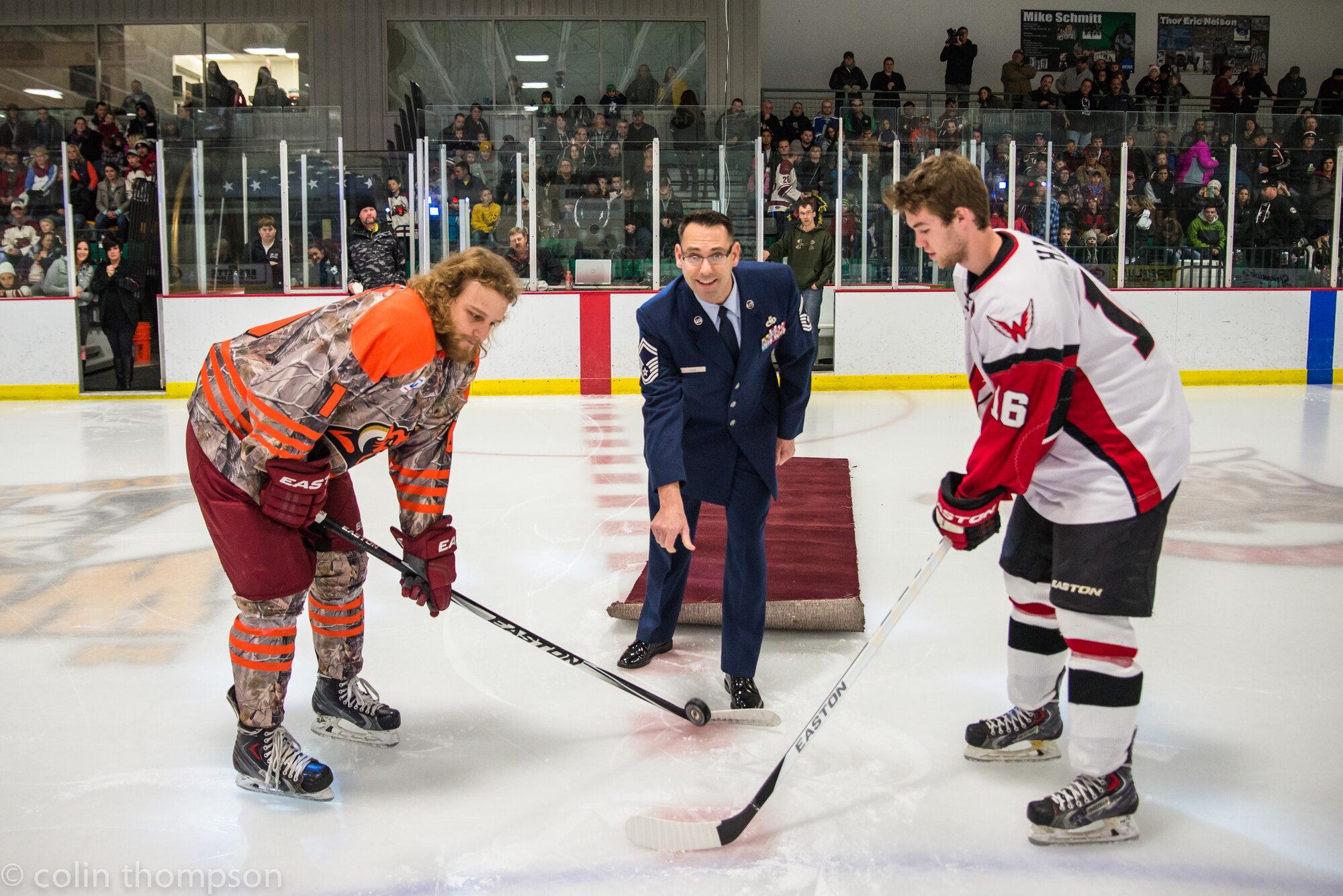 Senior Master Sgt. John Lium, 5th Aircraft Maintenance Squadron sortie support superintendent, drops a puck at the Minot Minotauros hockey game in Minot, N.D., Nov. 11, 2014. The teams let Lium drop the puck to honor him for his upcoming retirement and to thank him for his volunteer work with the team. (Courtesy photo) 