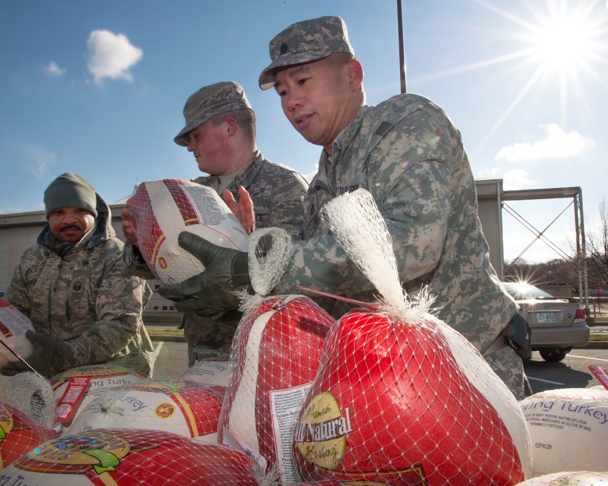 Master Sgt. Kevin C. Walker, Airman 1st Class Daniel D'Arcangelo and Sgt.1st Class Jimmy Lok collect donated frozen turkeys during the Annual Turkey Drop at the Commissary parking lot Nov.18. Members of the Chief's Group, Top Three Association and First Sergeant Council collected frozen turkey's during the morning for members of the Hanscom community in need this Thanksgiving. (U.S. Air Force photo by Mark Herlihy)