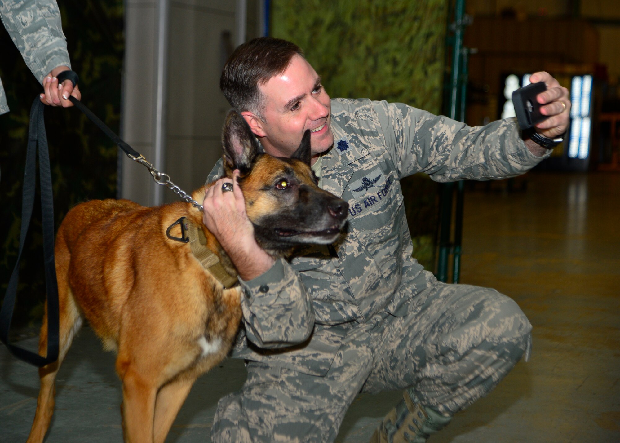 Lt. Col. Michael Phillips, 436th Mission Support Group deputy commander, takes a photo with Renzo, 436th Security Force Squadron military working dog, prior to his retirement ceremony Nov. 10, 2014, at Dover Air Force Base, Del. Renzo retired after serving eight years as a MWD with the 436th SFS. (U.S. Air Force photo/Airman 1st Class William Johnson)