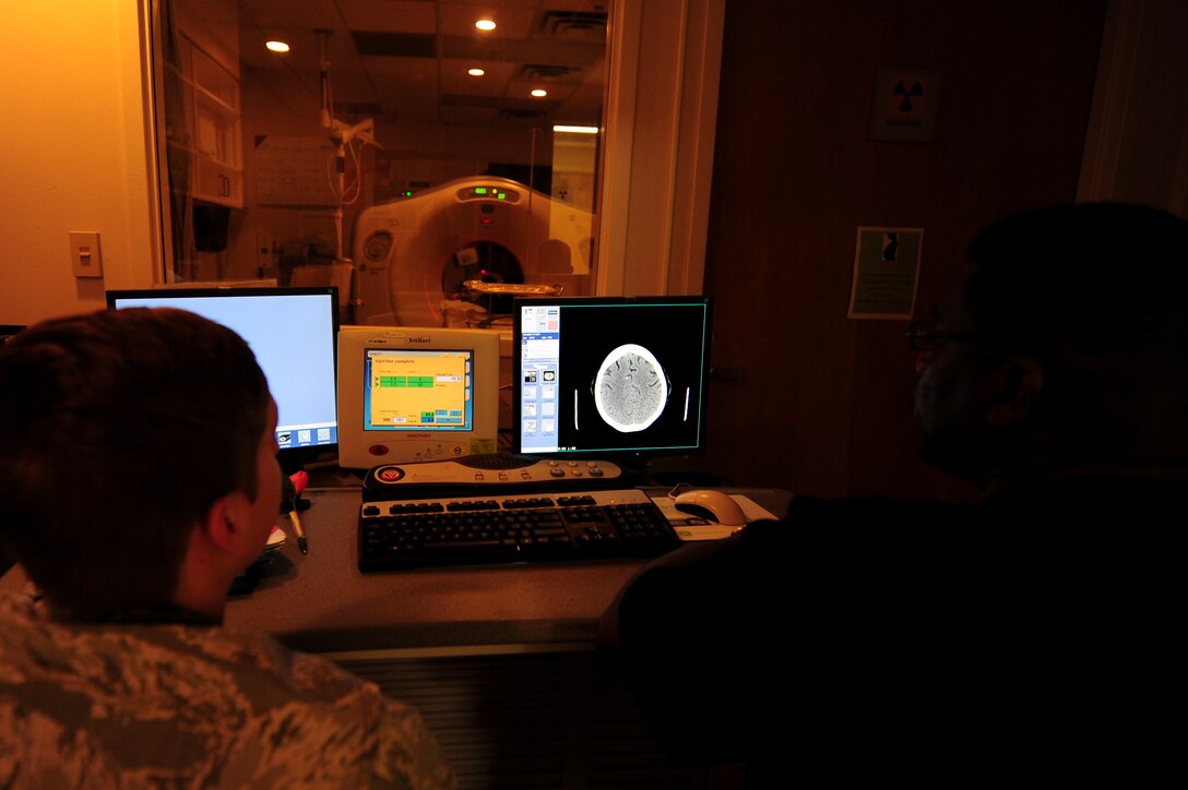 U.S. Air Force Staff Sgt. Matthew Stroud and Wayne Butler, 633rd Surgical Operations Squadron computed tomography technologists, perform a CT scan on a patient at Langley Air Force Base, Va., Nov. 14, 2014. CT scans are performed for diagnostic, treatment planning, interventional and screening purposes. (U.S. Air Force photo by Airman 1st Class Areca T. Wilson/Released) 