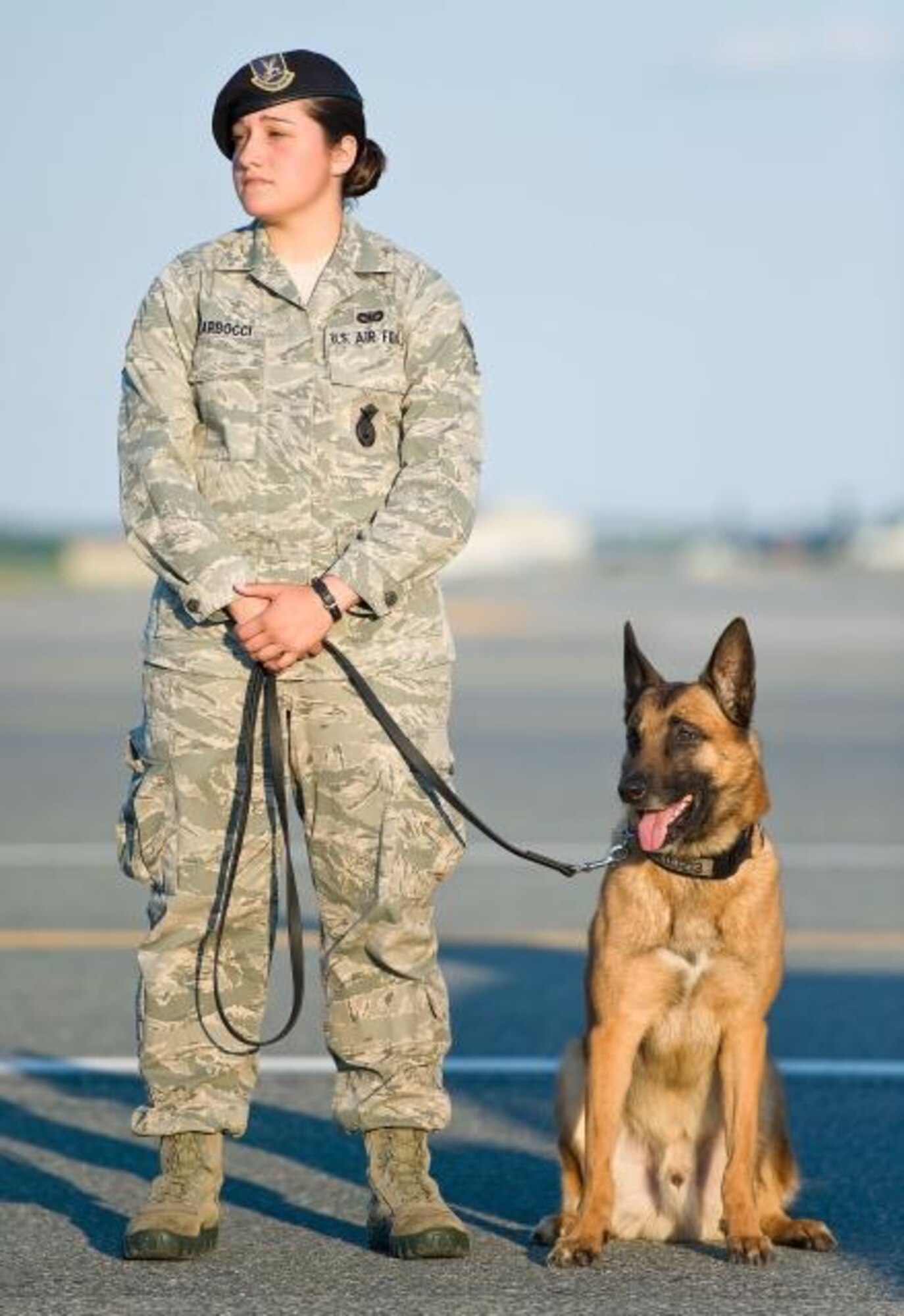 Staff Sgt. Tatiana Carbocci, former 436th Security Forces Squadron military working dog handler, and her K-9, Renzo, pay final respects to a U.S. Navy MWD handler during a dignified transfer June 2, 2014, at Dover Air Force Base, Del. Renzo was adopted by Carbocci after retiring from eight years of active duty service with the 436th SFS. (Courtesy Photo)