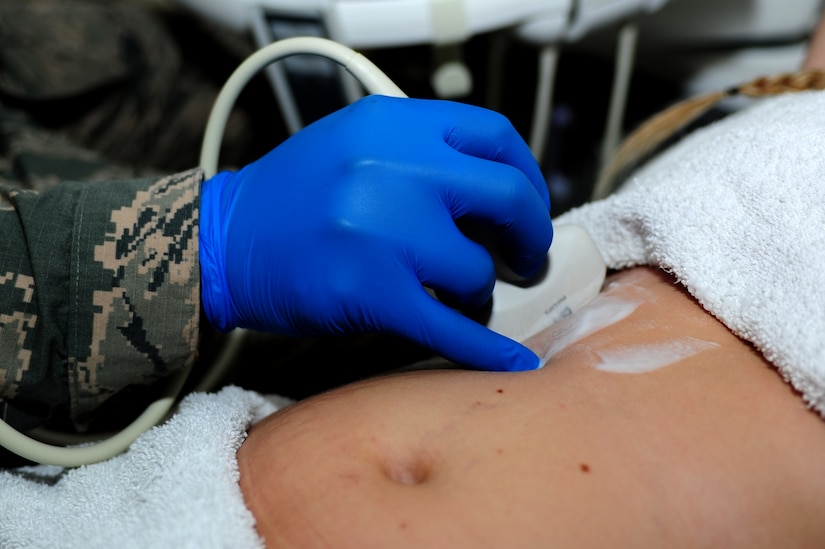 U.S. Air Force Staff Sgt. Thomas Wright, 633rd Surgical Operations Squadron diagnostics medical sonographer, performs an ultrasound on Sara Cearnel, 633rd SGCS diagnostics medical sonographer, at Langley Air Force Base, Va., Nov. 14, 2014. During an ultrasound, a transducer is moved over parts of the body to create images from sound waves. (U.S. Air Force photo by Airman 1st Class Areca T. Wilson/Released) 