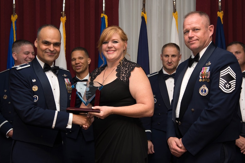 360th Recruiting Group Commander Col. Eric Espino and Chief Master Sgt. Scott Stoy (left) present Brenda Anthony the Spouse of the Year Award at the 319th Recruiting Squadron’s Annual Awards Banquet at the Minuteman Commons Nov. 3. Anthony, wife of Chief Master Sgt. David Anthony, 319th Recruiting Squadron superintendent, was selected among nominations from nine recruiting squadrons covering 19 states from the Canadian border to South Carolina and westward to Michigan. (U.S. Air Force photo by Mark Herlihy)