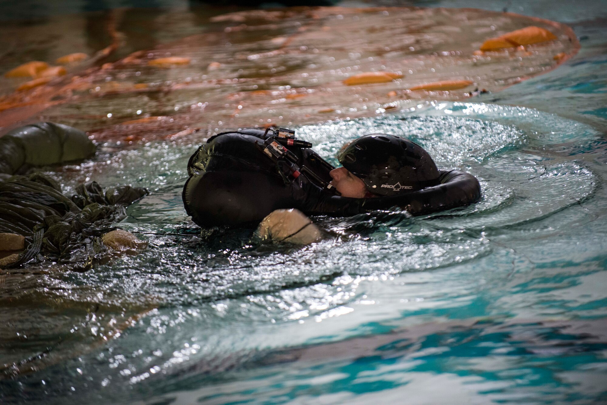 Staff Sgt. Anthony J. Barrette, 5th Operations Support Squadron operations and training NCO, and Survival, Evasion, Resistance, and Escape instructor, demonstrates the proper technique to get free of a parachute in the water during a survival course on Minot Air Force Base, Nov. 4, 2014. The course trains aviators on the proper techniques of survival in the event their aircraft went down over water, or enemy territory. (U.S. Air Force photo/Airman 1st Class Lauren Pitts) 