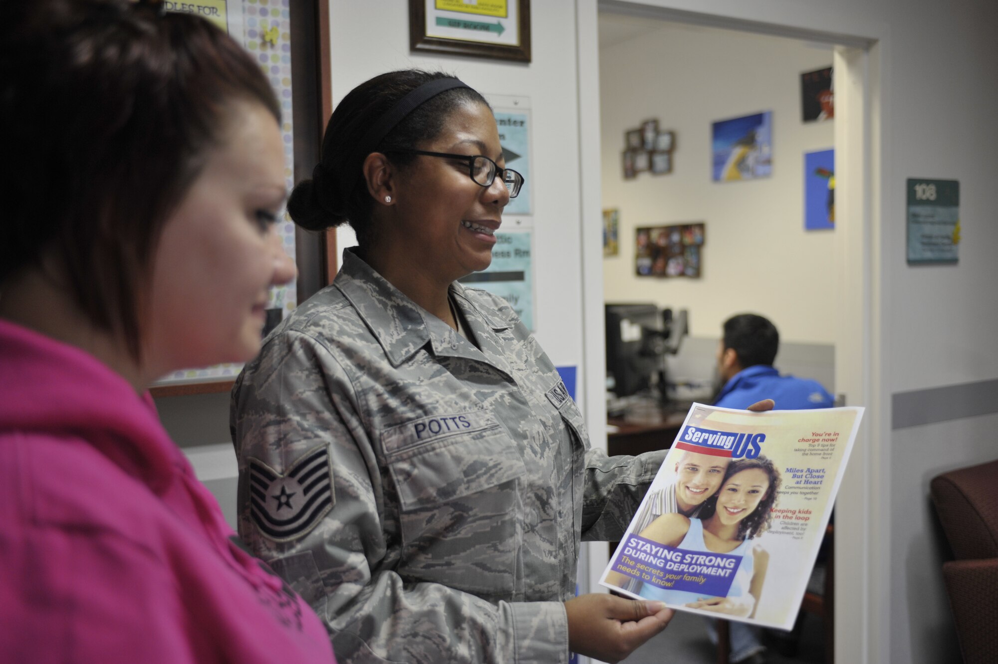 Tech. Sgt. Andrea Potts, the 92nd Force Support Squadron Airman and Family Readiness NCO in charge, shows  Jolene Raciborskia a brochure on how important staying strong during deployment is for military families Nov. 18, 2014, at the Airmen and Family Readiness Center at Fairchild Air Force Base, Wash. The AFRC assists Airmen and their families on how to cope with deployments, sustainment and reintegration. Potts’ leadership selected her as a member of Team Fairchild’s elite, Fairchild’s Finest. (U.S. Air Force photo/Airman 1st Class Taylor Bourgeous)