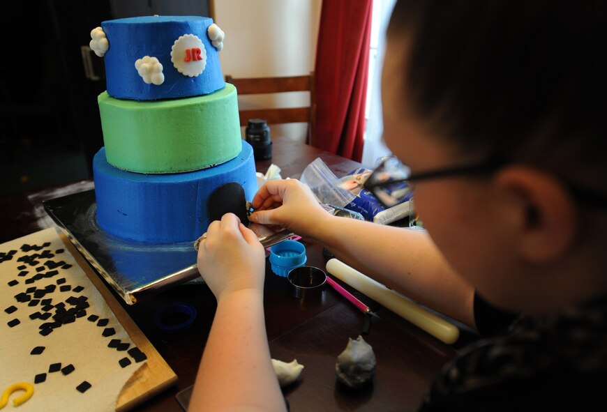 Staff Sgt. Jean Lawrence, prior 436th Operation Support Group unit deployment manager, adds details to a cake Nov. 7, 2014 at her home in Magnolia, Del. Lawrence has been able to apply lessons she's learned in the Air Force to help her in her cake business. (U.S. Air Force photo/Staff Sgt. Elizabeth Morris)