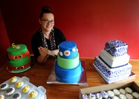 Staff Sgt. Jean Lawrence, prior 436th Operation Support Group unit deployment manager, poses with cakes and cupcakes that she is currently working on Nov. 7, 2014 at her home in Magnolia, Del. Lawrence has a passion for making cakes and has been creating them since 2011. (U.S. Air Force photo/Staff Sgt. Elizabeth Morris)