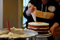 Staff Sgt. Jean Lawrence, prior 436th Operation Support Group unit deployment manager, ices a cake Nov. 5, 2014 at her home in Magnolia, Del. Lawrence will have served over ten years in the Air Force by the time she is medically retired. (U.S. Air Force photo/Staff Sgt. Elizabeth Morris)