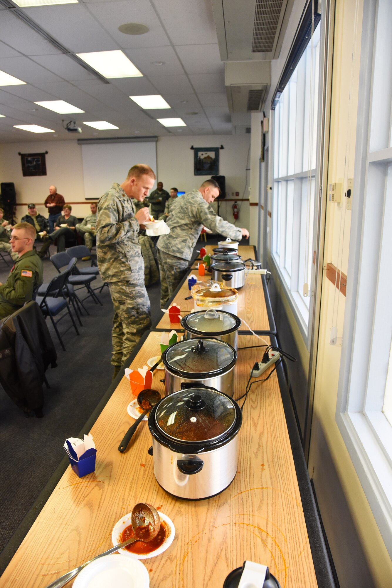 Team Malmstrom members taste test and enjoy 18 different chili recipes during wing one’s chili cook off event held at the base chapel Nov. 17. During the event, participants were able to vote on their favorite recipes by putting up to three raffle tickets in the contestant’s corresponding voting container. Judges of the event also had their own tickets to determine an overall winner in the event of a tie. (U.S. Air Force photo/ Airman 1st Class Collin Schmidt) 