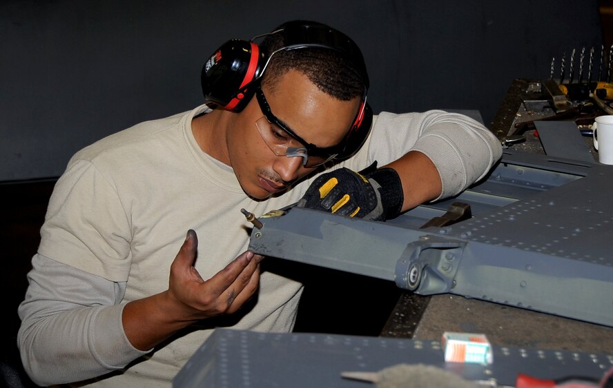 Staff Sgt. Montez Lee, 2nd Maintenance Squadron aircraft structural maintenance craftsman, inspects a rivet hole on a spoiler at Barksdale Air Force Base, La., Nov. 13, 2014. Sheet metal Airmen create metal parts for aircraft and other equipment when parts need to be replaced, reducing replacement part costs. (U.S. Air Force photo/Staff Sgt. Jason McCasland)