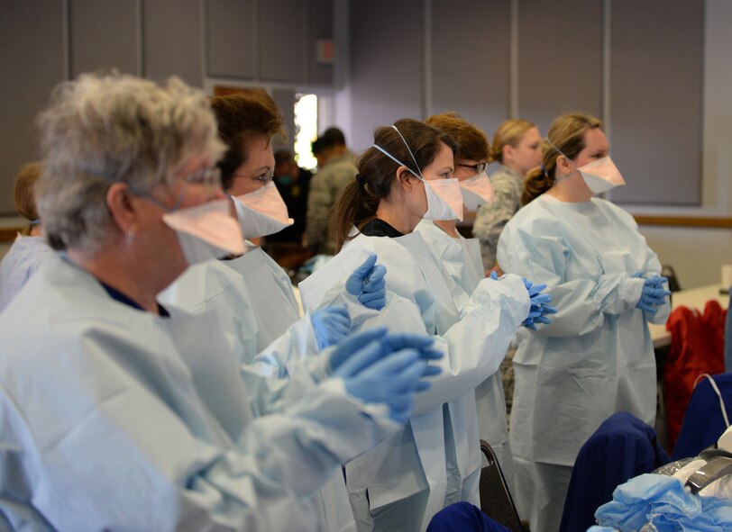 Local civilian medical personnel put on personal protective equipment for training at Centenary College of Louisiana in Shreveport, La., Nov. 14, 2014. The experienced medical professionals from large urban hospitals and smaller rural ones were training in the event of an Ebola outbreak. (U.S. Air Force photo/Airman 1st Class Curt Beach)