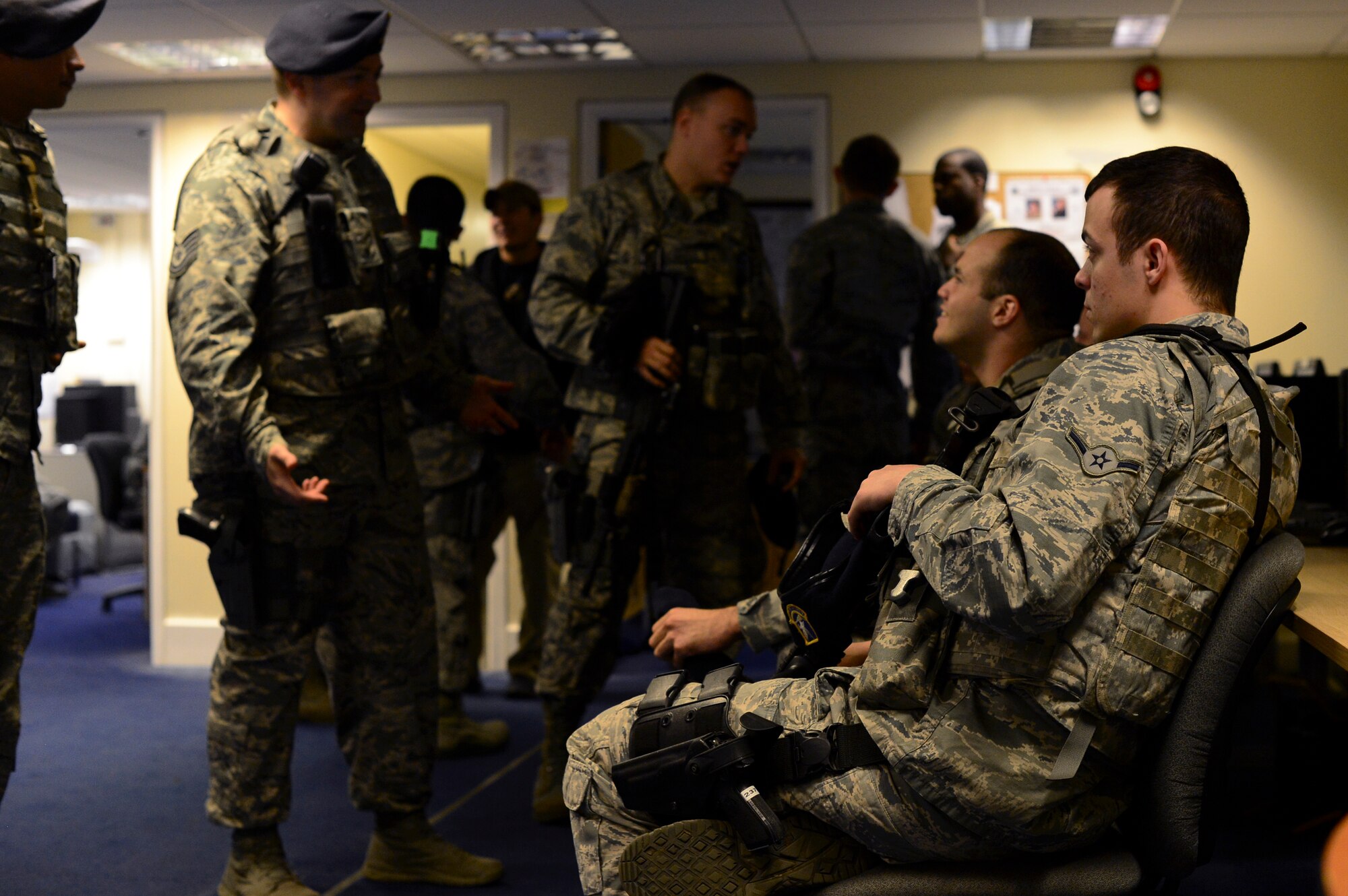 Airmen assigned to the 48th Security Forces Squadron gather for a shift change in a squadron briefing room at Royal Air Force Lakenheath, England, Nov. 12, 2014. During this time, members are briefed about current base operations and responsibilities before their shift begins. (U.S. Air Force photo by Senior Airman Erin O’Shea/Released) 