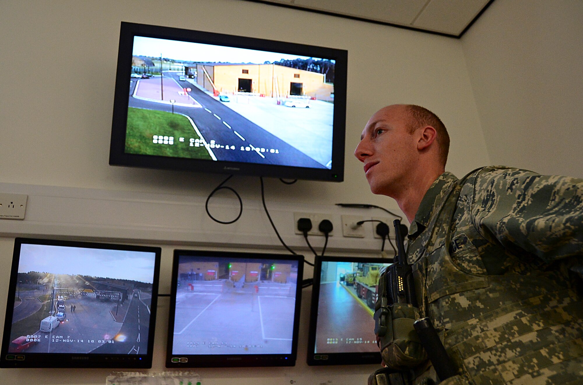 Airman 1st Class Joshua Smith, 48th Security Forces Squadron response force member, activates the large vehicle inspection site gates from a console in the control room at Royal Air Force Lakenheath, England, Nov. 12, 2014. Smith monitors the gates, allowing contractors and non-department of defense employed civilians to access the base after clearing security customs. (U.S. Air Force photo by Senior Airman Erin O’Shea/Released) 