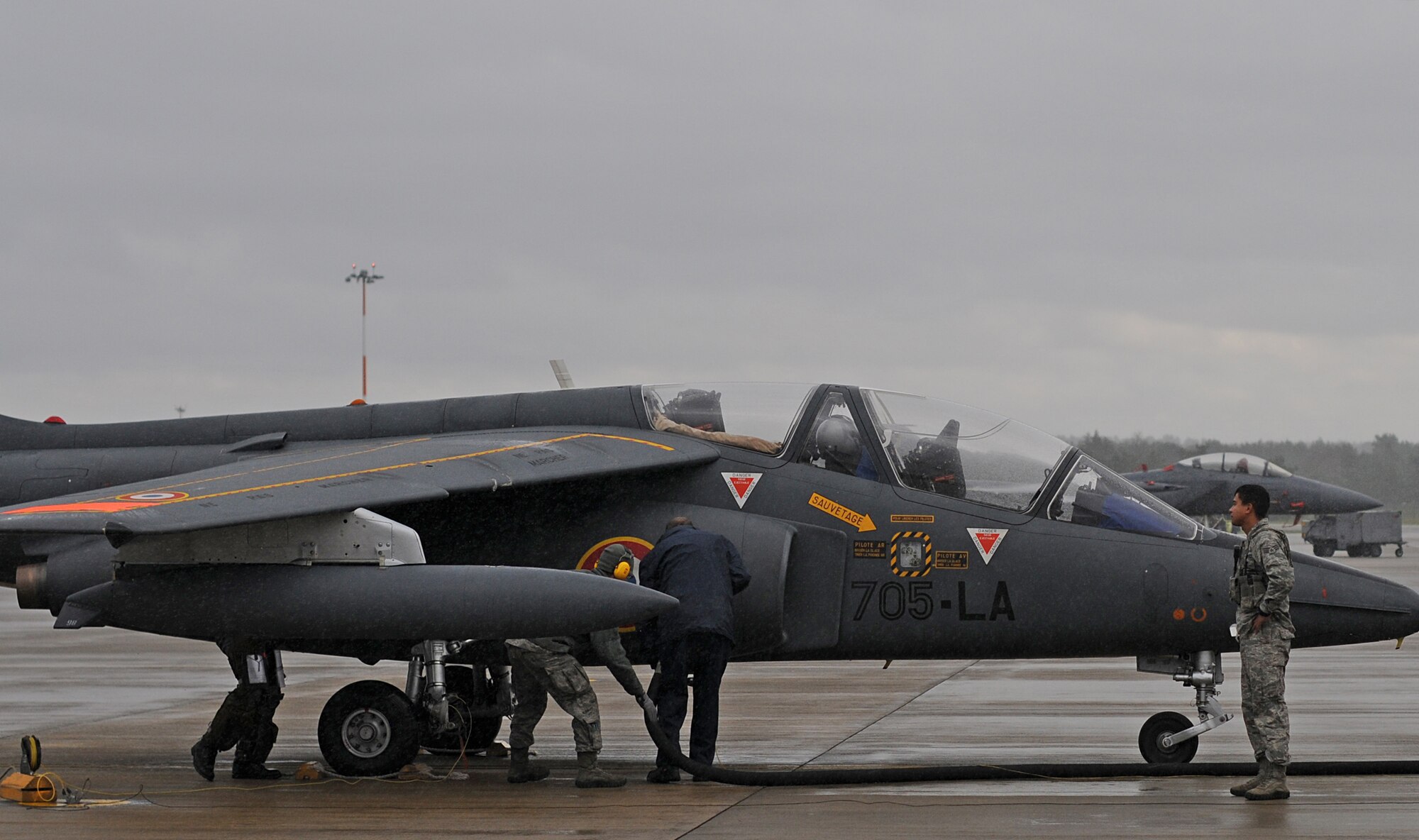 Senior Airman Manuel Garcia, 48th Security Forces Squadron response force leader, oversees a French pilot in transit on the flightline at Royal Air Force Lakenheath, England, Nov. 12, 2014. A security forces member must oversee foreign transient aircraft that land on the flightline, to ensure they abide by all security measures. (U.S. Air Force photo by Senior Airman Erin O’Shea/Released) 