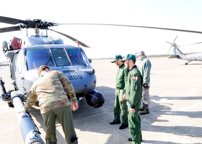 Japan Air Rescue Wing Operations Group Commander Col. Yutaka Harada, listens to U.S. Air Force 1st Lt. Dirk Strykowski, 33rd Rescue Squadron pilot, explain a part on an HH-60G Pave Hawk at Komatsu Air Base, Japan, Nov. 12, 2014. Harada visited the Komatsu Air Rescue Squadron and to watch the joint training being conducted during Exercise Keen Sword. The 33rd RQS is assigned to Kadena Air Base, Japan. (U.S. Air Force photo by 2nd Lt. Erik Anthony/Released) 
