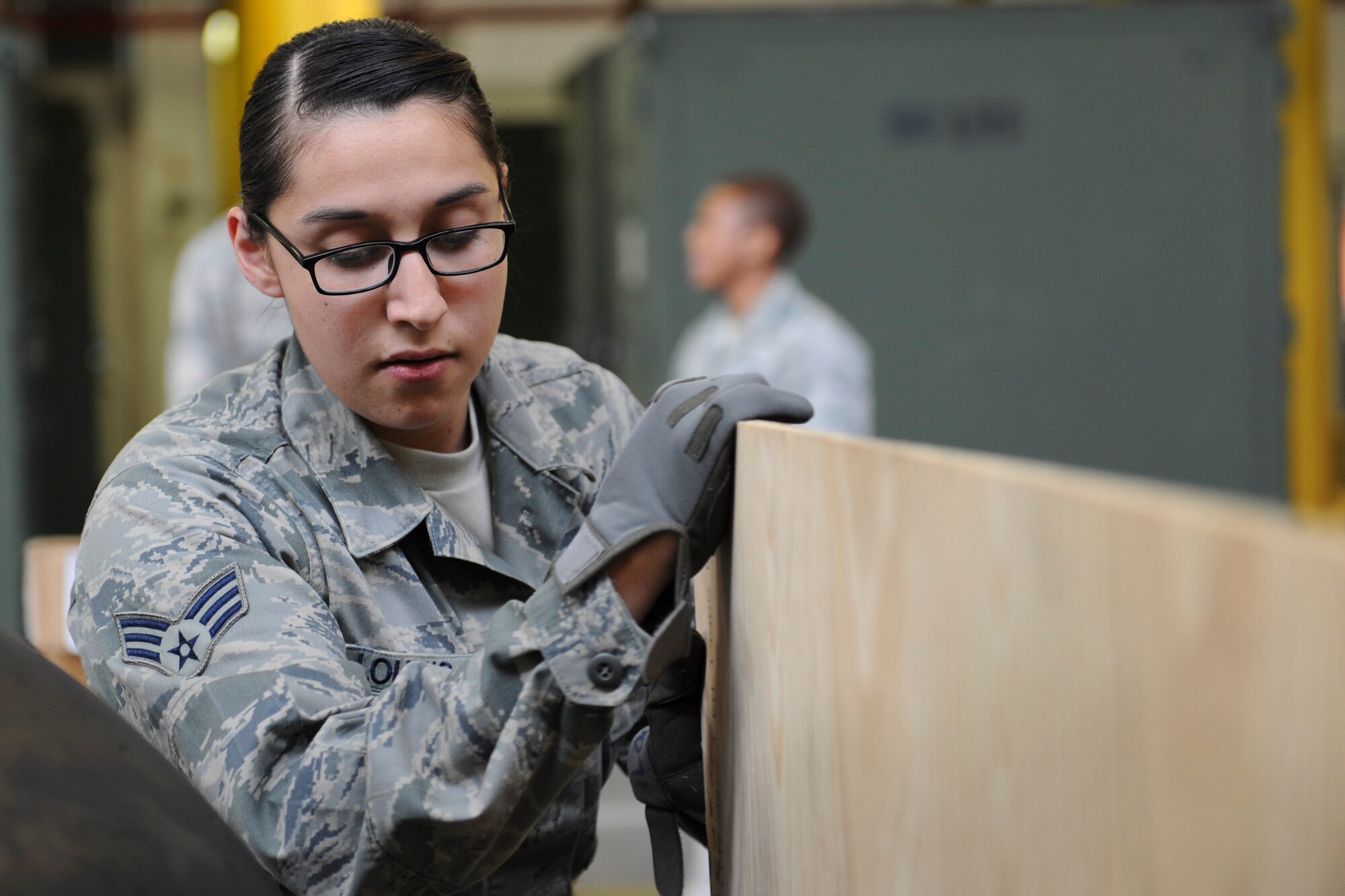 Senior Airman Bianca Loucks, 86th LRS supply journeyman, moves a wooden board in between C-130J Super Hercules wheels to avoid damaging them on Ramstein Air Base, Germany, Sep. 24, 2014. The 86th LRS is a 24-hour operation providing fuel, deployment necessities and equipment for all inbound and outbound aircraft and military members. (U.S. Air Force photo/Airman 1st Class Michael Stuart) 