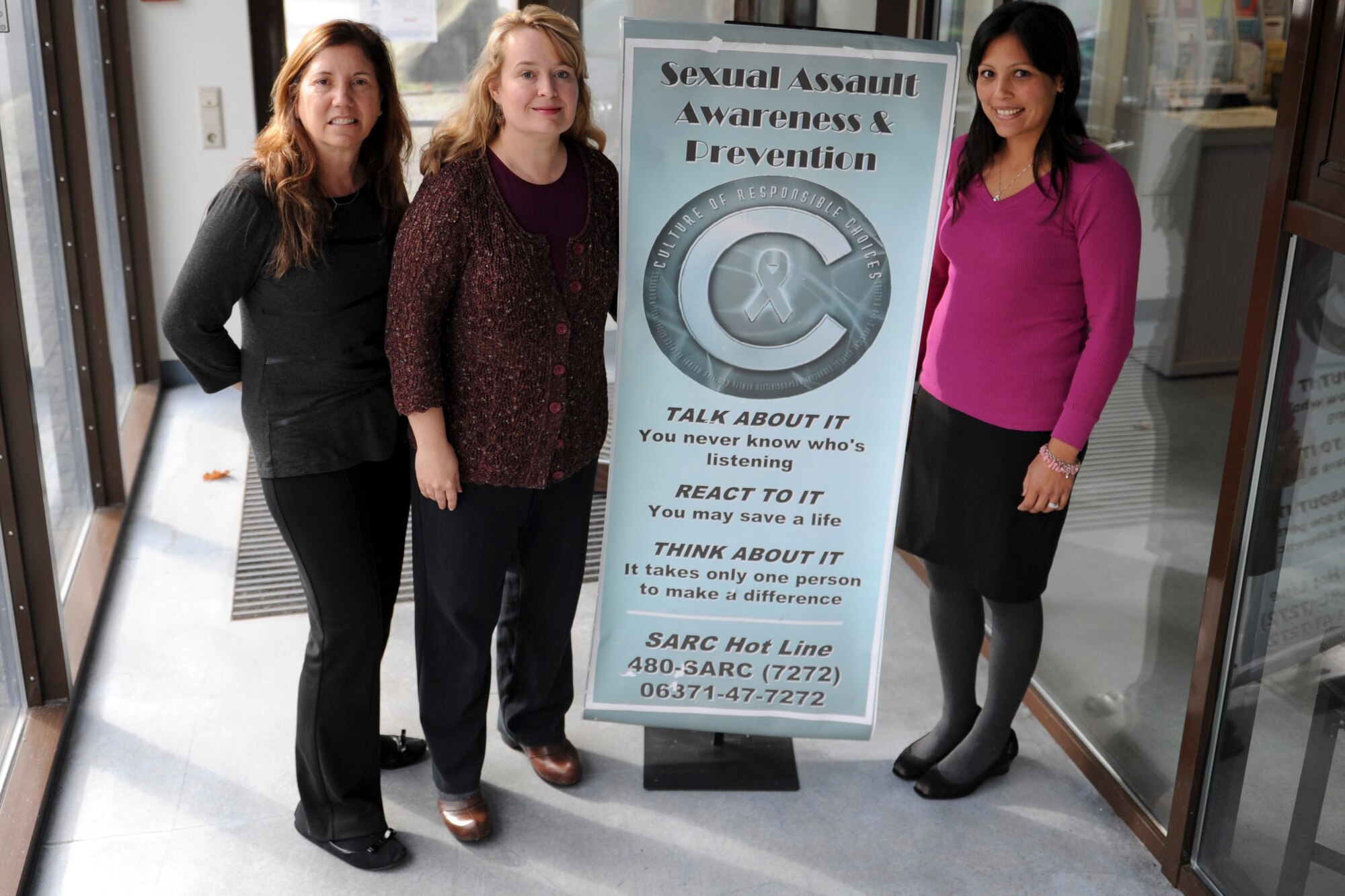 Valerie Seitz, family advocacy outreach manager, Carmen Schott, sexual assault response coordinator and Desiree Amby, sexual assault victim advocate join forces for National Domestic Violence Awareness month on Ramstein Air Base, Germany, Sep. 24, 2014. National Domestic Violence Awareness month is bringing awareness to sexual assault occurring between intimate partners and within marriages. (U.S. Air Force photo/Airman 1st Class Michael Stuart)