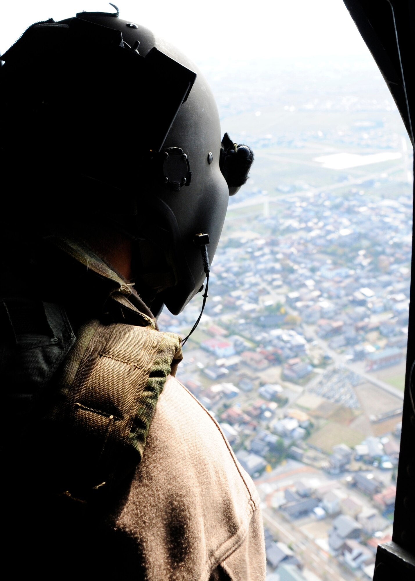 A U.S. Air Force HH-60G Pave Hawk special missions aviator admires the view of Komatsu, Japan after successfully completing a joint training mission with the Japan Air Self-Defense Force Komatsu Air Rescue Squadron during Exercise Keen Sword 2015, Nov. 12, 2014. The teams successfully extracted a simulated drowning victim during the annual joint-bilateral training exercise, which is designed to increase the interoperability required to support the defense of Japan, respond to a potential crisis and offer humanitarian assistance.  (U.S. Air Force photo by 2nd Lt. Erik Anthony/Released)