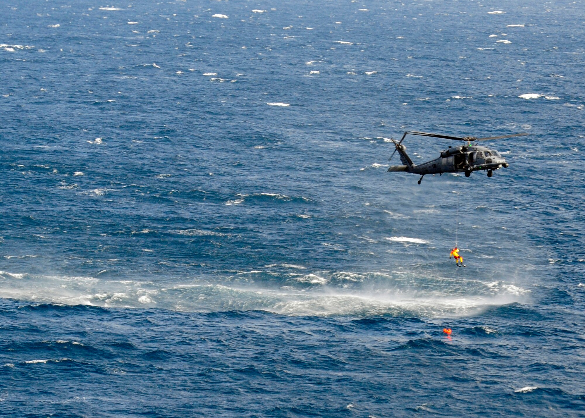 A U.S. Air Force pararescueman from the 212th Rescue Squadron repels from one of the 33rd Rescue Squadron's HH-60G Pave Hawk helicopters to save a simulated drowning victim in a scenario that was part of exercise Keen Sword 2015 near Komatsu Air Base, Japan, Nov. 12, 2014. The scenario was designed for joint-bilateral training with Japan Self-Defense Force rescue crews. The training allows aircrews and pararescuemen to practice what they would do in a real world situation. The 212th RQS is assigned to Joint Base Elmendorf-Richardson, Alaska, and the 33rd RQS is assigned to Kadena Air Base, Japan. (U.S. Air Force photo by 2nd Lt. Erik Anthony/Released)