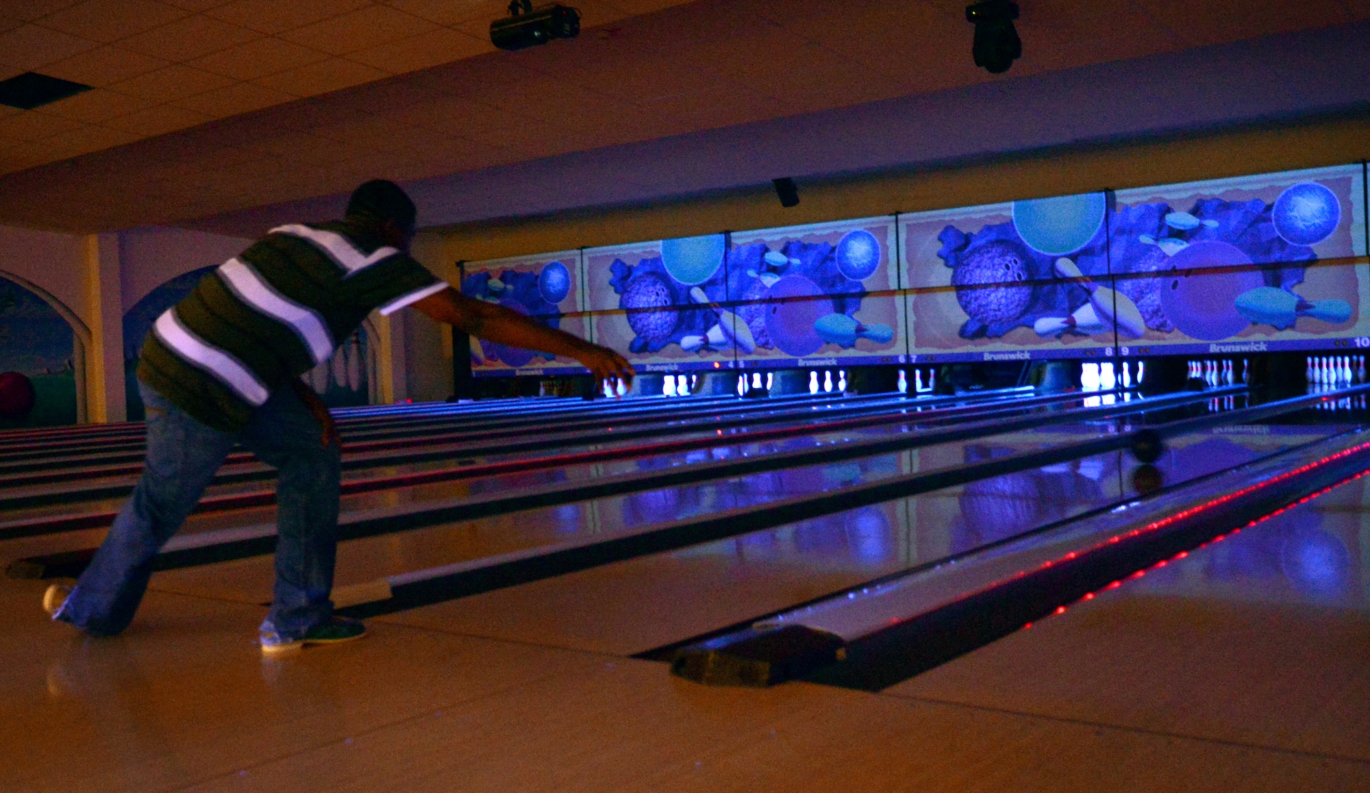 Airman 1st Class Benjamin George, 86th Vehicle Readiness Squadron, rolls a bowling ball down a lane in the Ramstein Bowling Center at Ramstein Air Base, Germany, Aug. 29, 2014. George and other Airmen took advantage of a free bowling event as part of the Single Airman Program Initiative. SAPI is an Air Force initiative whose goal is to provide force support squadrons with the resources to foster a strong culture, mission and sense of community for single Airmen. (U.S. Air Force photo/Senior Airman Timothy Moore)