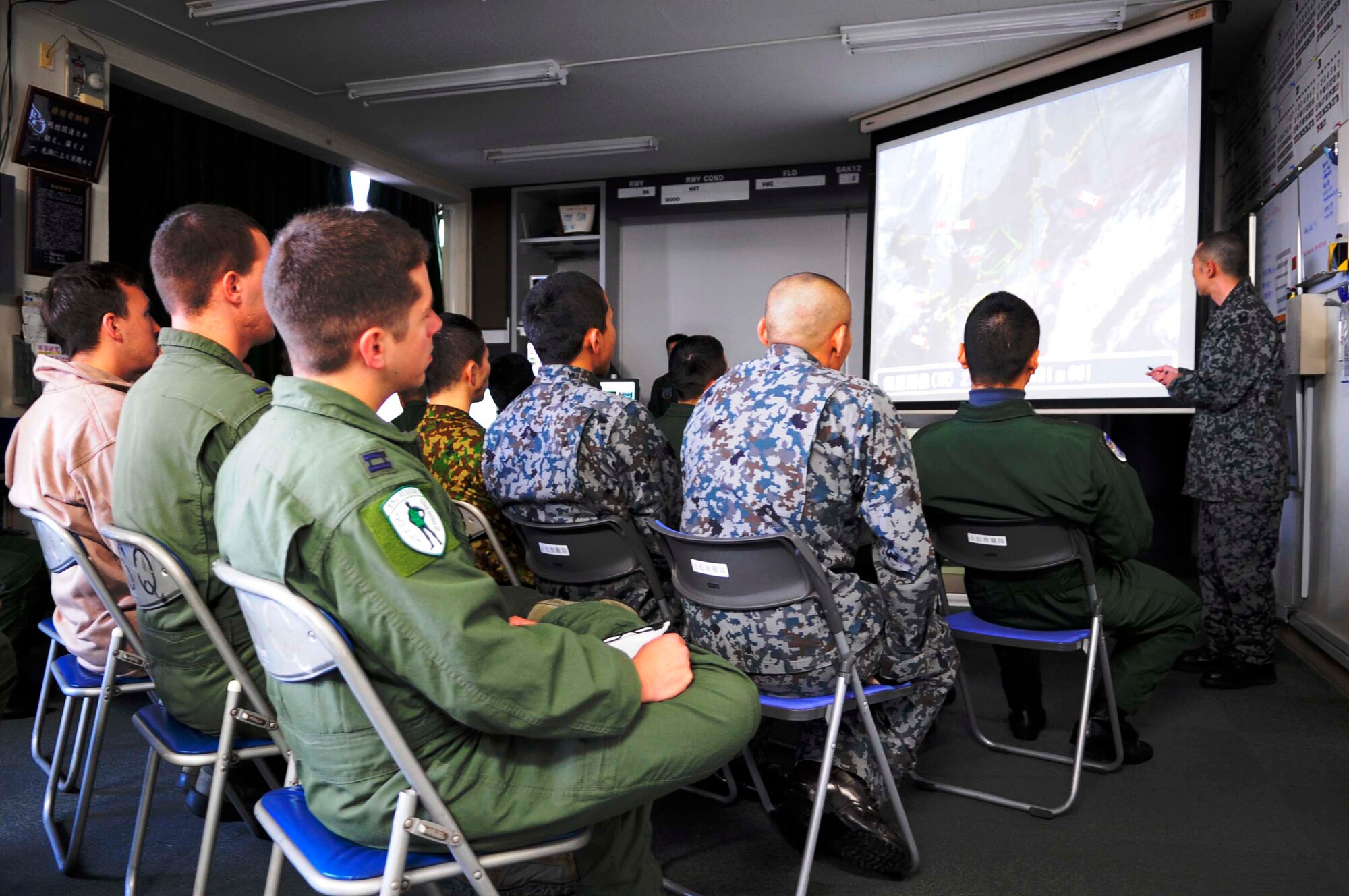 Members of the Japan Air Self-Defense Force?s Komatsu Air Rescue Squadron and the U.S. Air Force's 33rd Rescue Squadron gathered for a group weather brief during Exercise Keen Sword 2015 on Komatsu Air Base, Japan, Nov. 12, 2014. Keen Sword is a joint-bilateral exercise designed to increase the interoperability required to support the defense of Japan and respond to a potential crisis in the region. The 33rd RQS is assigned to Kadena Air Base, Japan. (U.S. Air Force photo by 2nd Lt. Erik Anthony/Released)