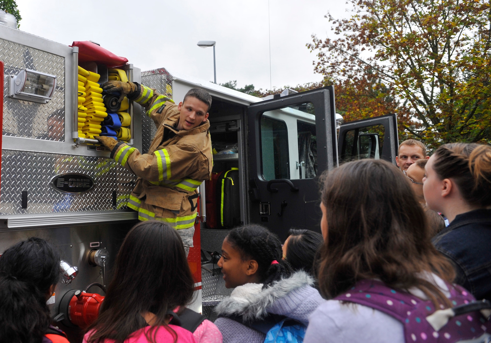 Airman 1st Class Jacob Frost, 86th Fire Department firefighter, shows Ramstein Middle School students the hoses on a fire truck during Fire Prevention Week on Oct. 9, 2014 at Ramstein Air Base, Germany. The students learned about the equipment the 86th CES firefighters use during training and real-world situations. (U.S. Air Force photo/Airman Larissa Greatwood) 