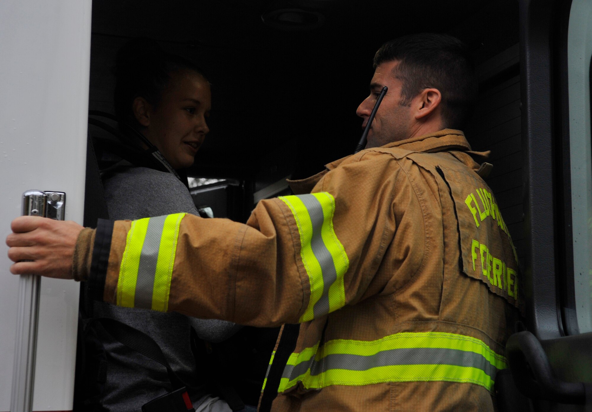 Tech Sgt. Justin Luzier, 86th Civil Engineer Squadron Fire Department district chief, teaches a Ramstein Middle School student about how firefighters respond to emergencies on Oct. 9, 2014 at Ramstein Air Base, Germany. The students had the chance to ask the 86th CES firefighters questions and sit in the front seats of a fire truck. (U.S. Air Force photo/Airman Larissa Greatwood)