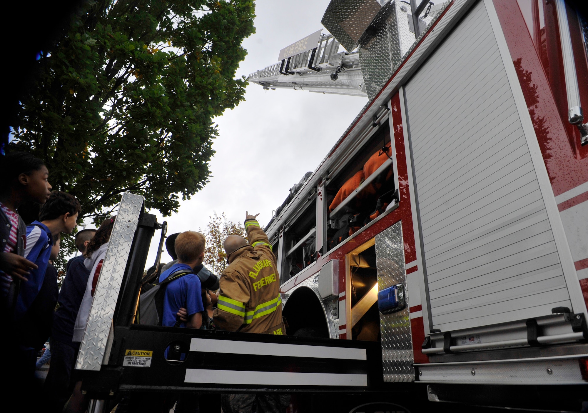 Senior Airman Matthew Clark, 86th Civil Engineer Squadron Fire Department driver and operator, teaches Ramstein Middle School students about fire truck equipment Oct. 9, 2014 at Ramstein Air Base, Germany. The 86th CES firefighters came out to the middle school to talk to the students about their job and the importance of fire safety. (U.S. Air Force photo/Airman Larissa Greatwood)