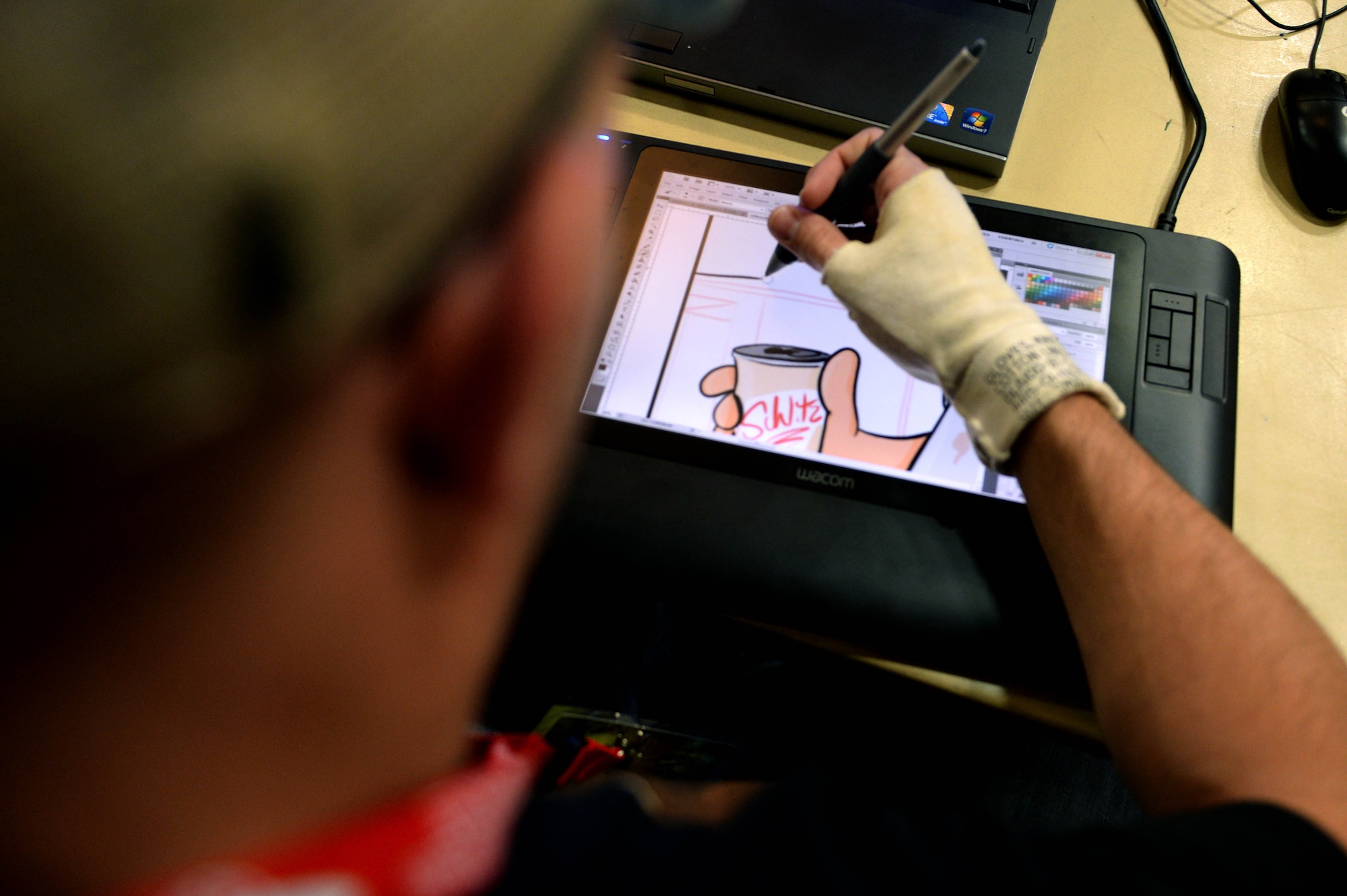 Austin May, artist of the Air Force Times comic “Air Force Toons,” draws for his fans during Operation Sci-Fi Con 2015 in the Landscheid Room at Club Eifel on Spangdahlem Air Base, Germany, Nov. 15, 2014. May drew pictures at his booth while a television monitor provided a live feed of his work to onlookers. (U.S. Air Force photo by Airman 1st Class Timothy Kim/Released)