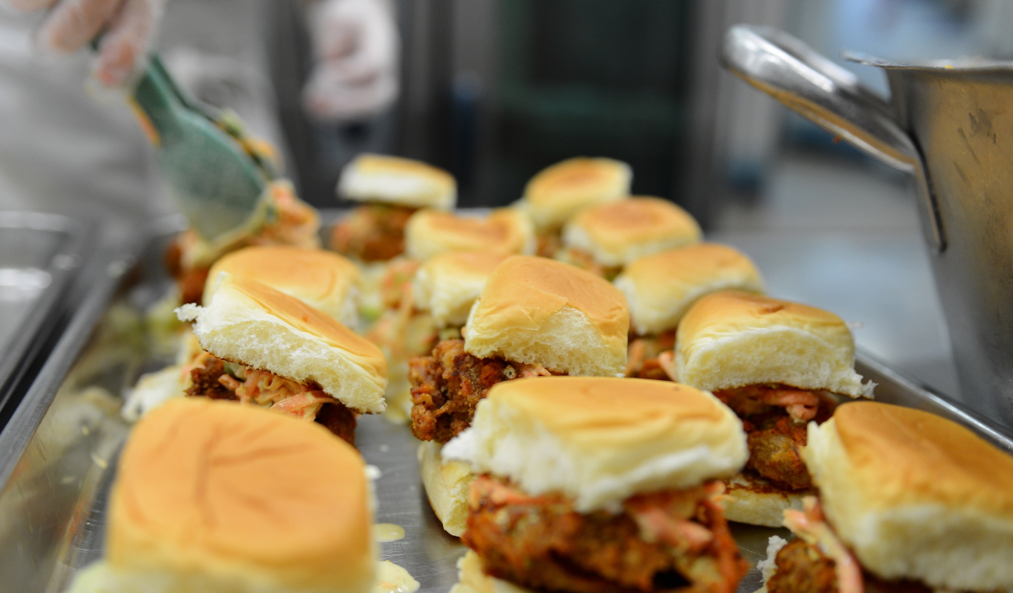 Buffalo chicken sliders are arranged by a 52nd Force Support Squadron Airman during the “Messlords” luncheon at the Mosel Dining Facility on Spangdahlem Air Base, Germany, Nov. 15, 2014. Other items served during the luncheon included burger sliders, fish tacos and an assortment of salsas. (U.S. Air Force photo by Airman 1st Class Luke Kitterman/Released)