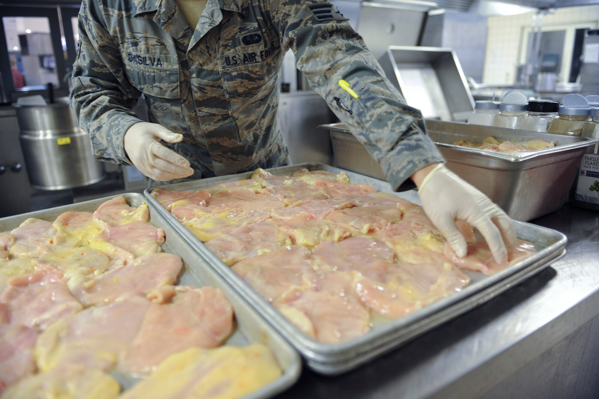 Senior Airman Jonathan DaSilva, 786th Force Support Squadron food service journeyman, prepares chicken breasts for lunch in the Rhineland Inn Dining Facility on Ramstein Air Base, Germany, Oct. 8, 2014. The Rhineland Inn Dining Facility offers four meals a day, providing Airmen a full-service main line, snack line and sandwich bar. (U.S. Air Force photo/Airman 1st Class Michael Stuart)