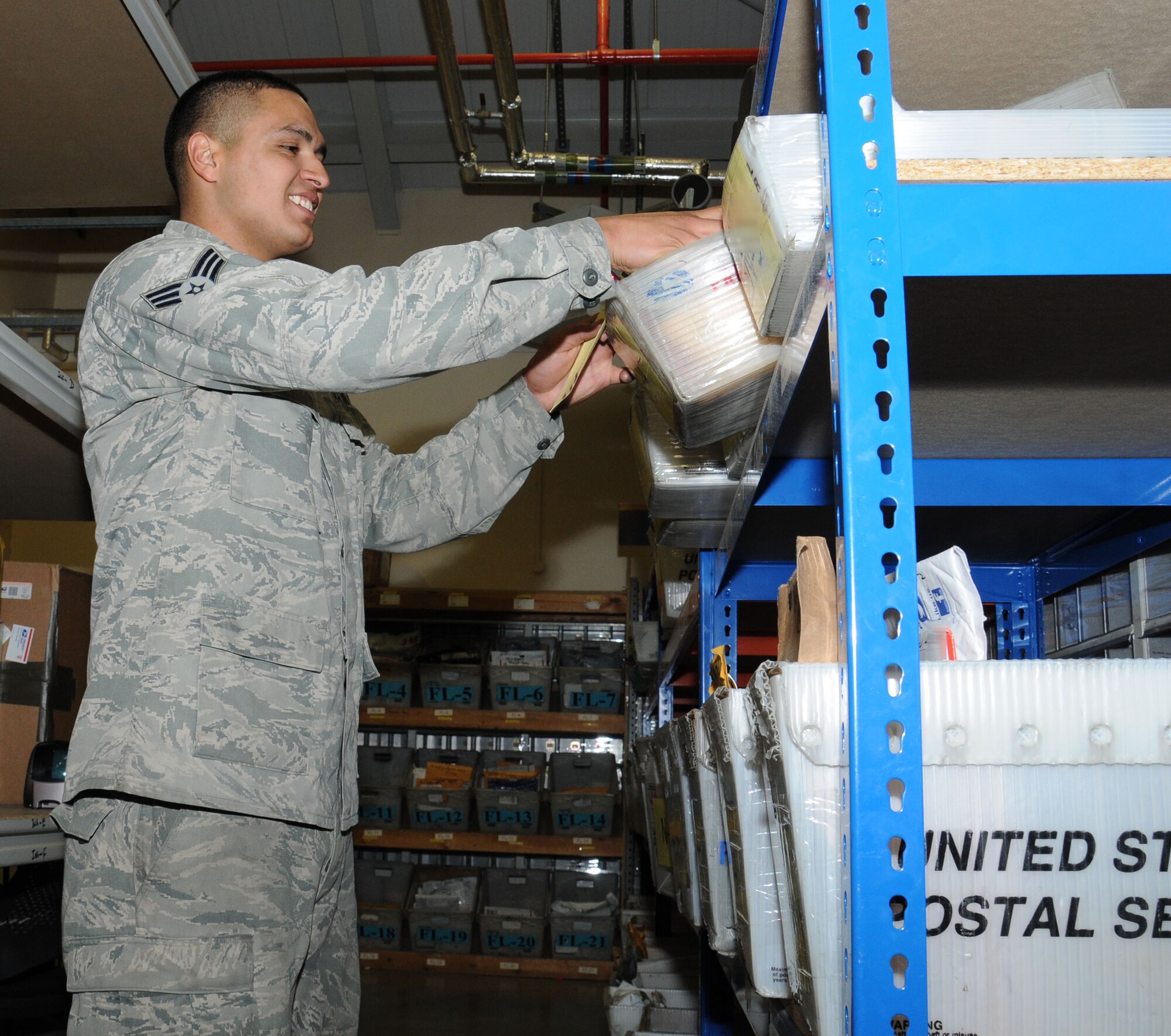 U.S. Air Force Senior Airman Oscar Campos-Ortiz, 100th Communications Squadron postal clerk from Dallas, collects a package for a customer from the mail holding area Oct. 24, 2014, on RAF Mildenhall, England. The RAF Mildenhall Post Office is open Monday to Friday for package pick up and drop off 8 a.m. to 5 p.m., and Saturday 10 a.m. to 1 p.m. (U.S. Air Force photo by Gina Randall/Released)