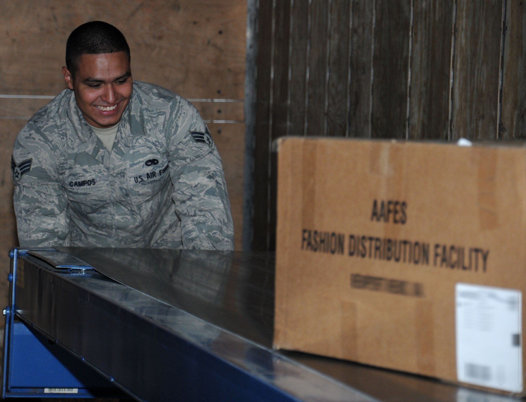 U.S. Air Force Senior Airman Oscar Campos-Ortiz, 100th Communications Squadron postal clerk from Dallas, moves a conveyor belt after using it to load packages to a mail truck Oct. 24, 2014, on RAF Mildenhall, England. Mail is initially received at London Heathrow Airport, and then makes its journey to RAF Mildenhall. (U.S. Air Force photo by Gina Randall/Released)