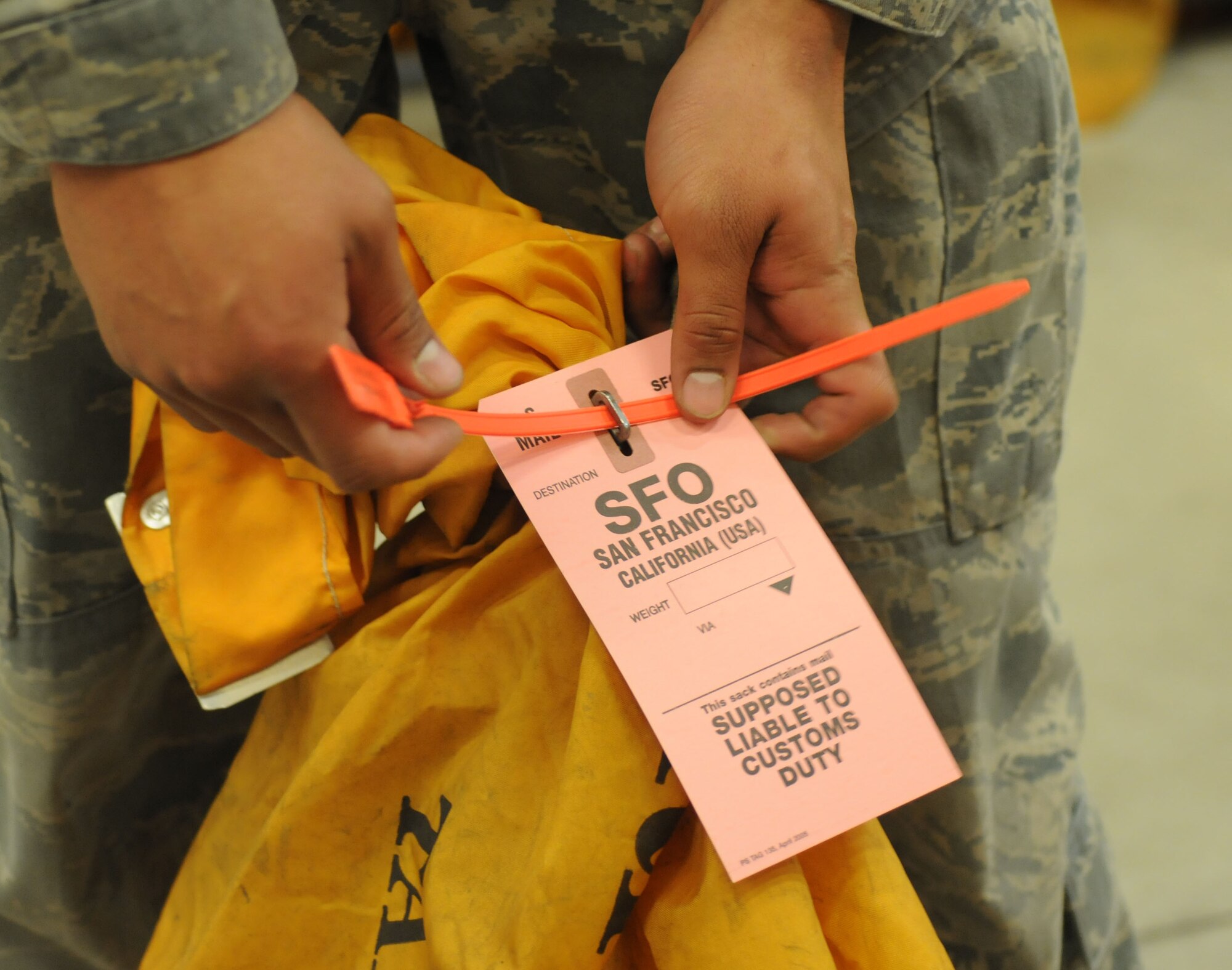 U.S. Air Force Senior Airman Oscar Campos-Ortiz, 100th Communications Squadron postal clerk from Dallas, closes a mail bag prior to weighing it and loading it onto a mail truck Oct. 24, 2014, on RAF Mildenhall, England. Mail is sorted by destination zip code, then sent to its respective airport such as San Francisco International Airport. (U.S. Air Force photo by Gina Randall/Released)
