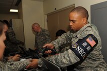 U.S. Air Force Tech. Sgt. William Saul, 18th Communications Squadron quality assurance officer, scans a bracelet with a noncombatant tracking system barcode on Kadena Air Base, Japan, Nov. 14, 2014. The noncombatant tracking system keeps track of travelers by assigning barcodes to each person and pet to be scanned at various points throughout their journey. The information is compiled into a log so sponsors can see where and when their family members' barcodes were last scanned. (U.S. Air Force photo by Airman 1st Class Zade C. Vadnais/Released)  