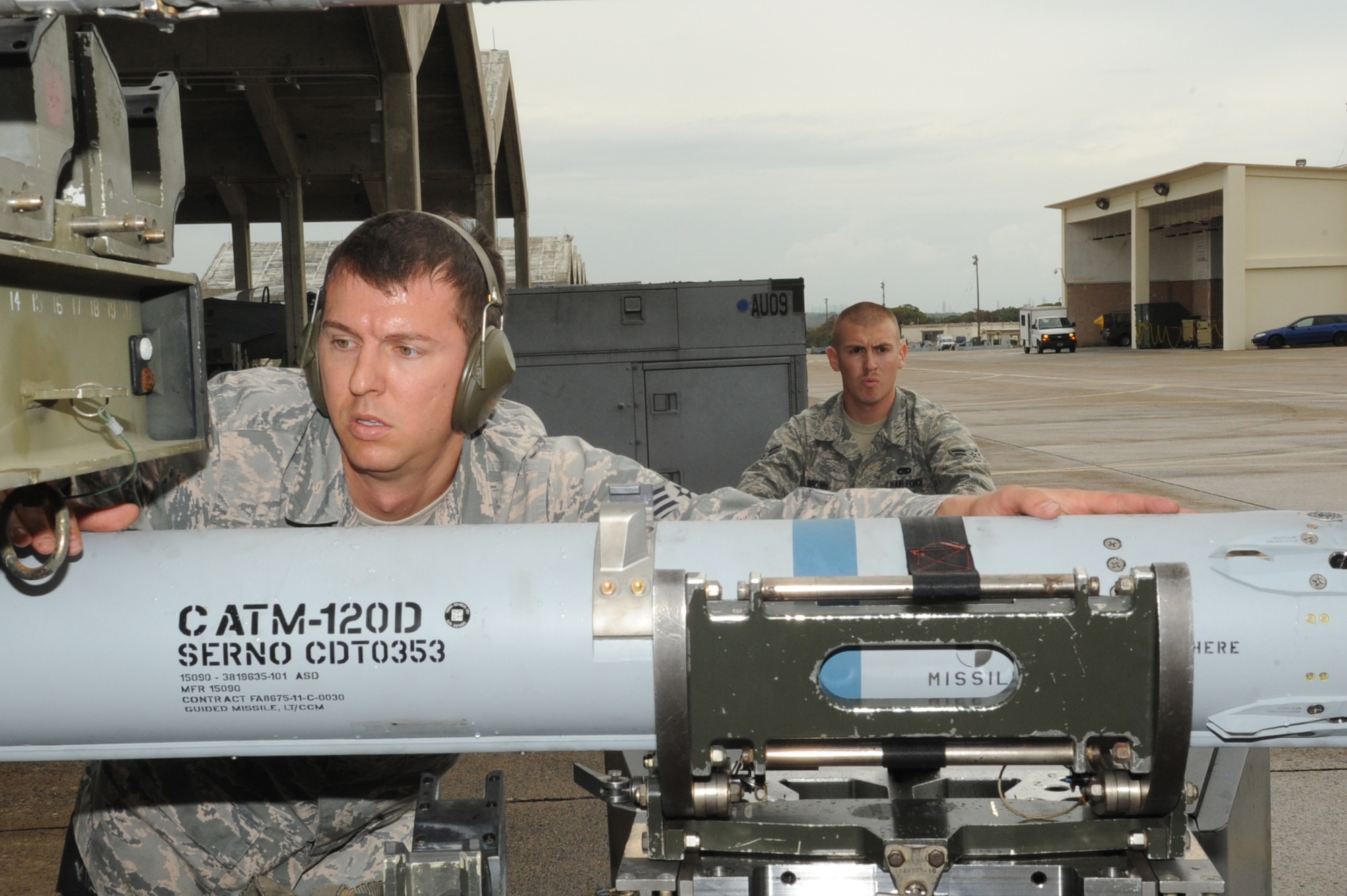 U.S. Air Force Staff Sgt. Jeffrey Burbank, 18th Aircraft Maintenance Squadron weapons load crew chief, ensures the CATM-120 missile doesn't touch the trailer while Airman 1st Class Ryan Brown, 18th AMXS weapons load crew member drives the MJ-1 Jammer, a missile mover, during the quarterly weapons loading competition at Kadena Air Base, Japan, Nov. 17, 2014. The teams were inspected on safety, reliability and technical orders of loading the F-15 Eagle. (U.S. Air Force photo by Airman 1st Class Zackary A. Henry/Released)