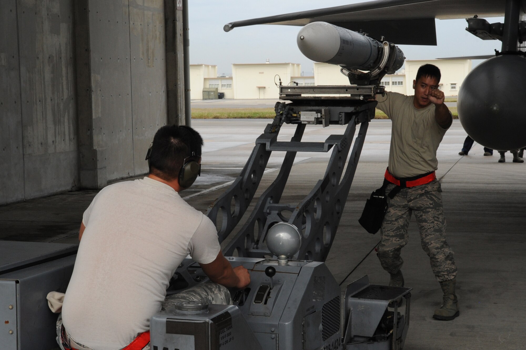 U.S. Air Force Senior Airman Chinh Nguyen, 18th Aircraft Maintenance Squadron weapons load crew member, drives the MJ-1 Jammer, a missile mover, while Staff Sgt. Paolo Santos, 18th AMXS weapons load crew chief, helps him navigate into place during the quarterly weapons loading competition at Kadena Air Base, Japan, Nov. 17, 2014. The competition tests the team's ability to load weapons on F-15C Eagles in a fast and safe manner. This competition was held between the 44th and 67th Aircraft Maintenance Units of the 18th AMXS. (U.S. Air Force photo by Airman 1st Class Zackary A. Henry/Released)